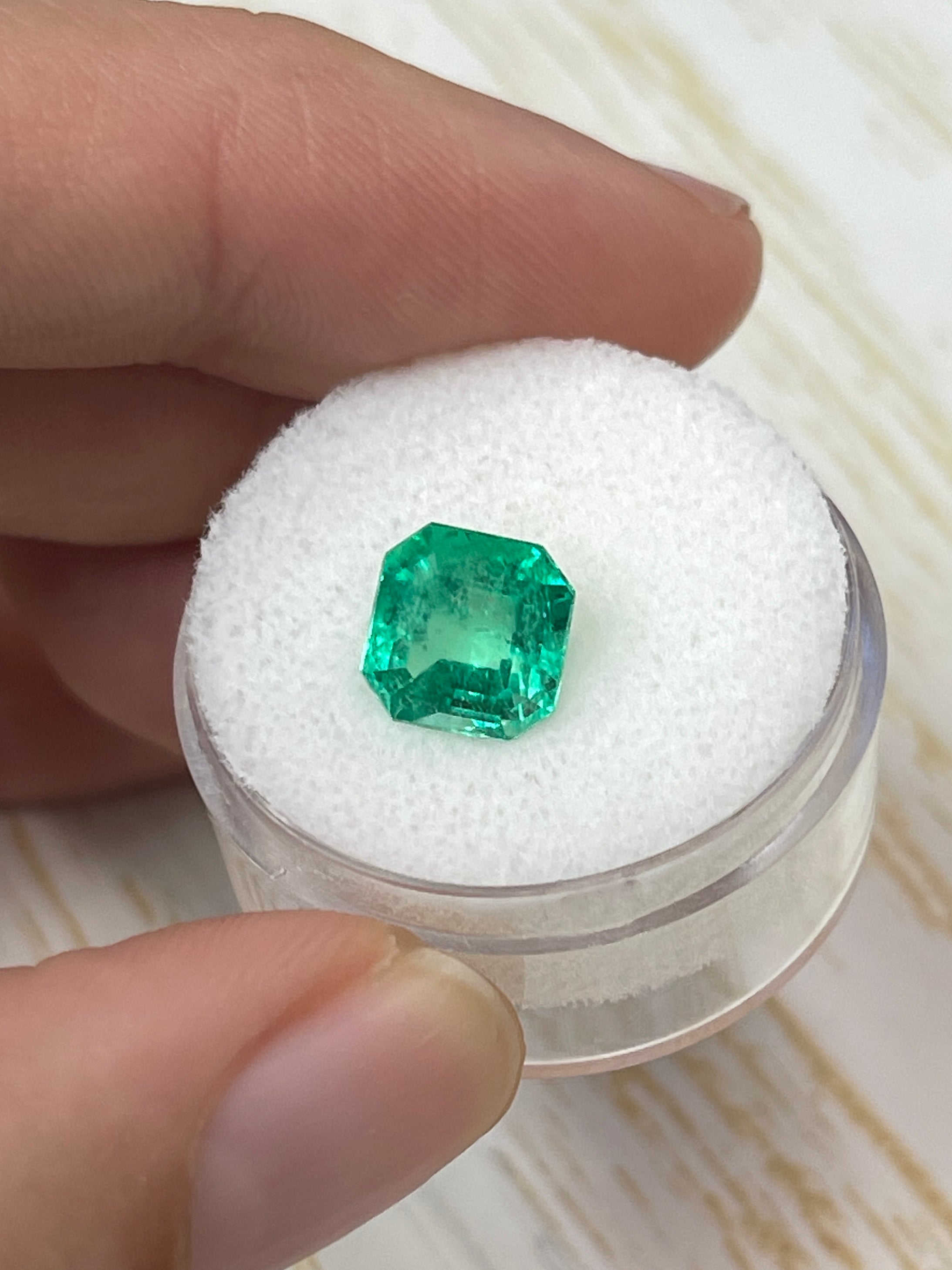 2.71 carat electric yellowish green natural loose Colombian emerald in Asscher cut, displayed by JR Colombian Emeralds.