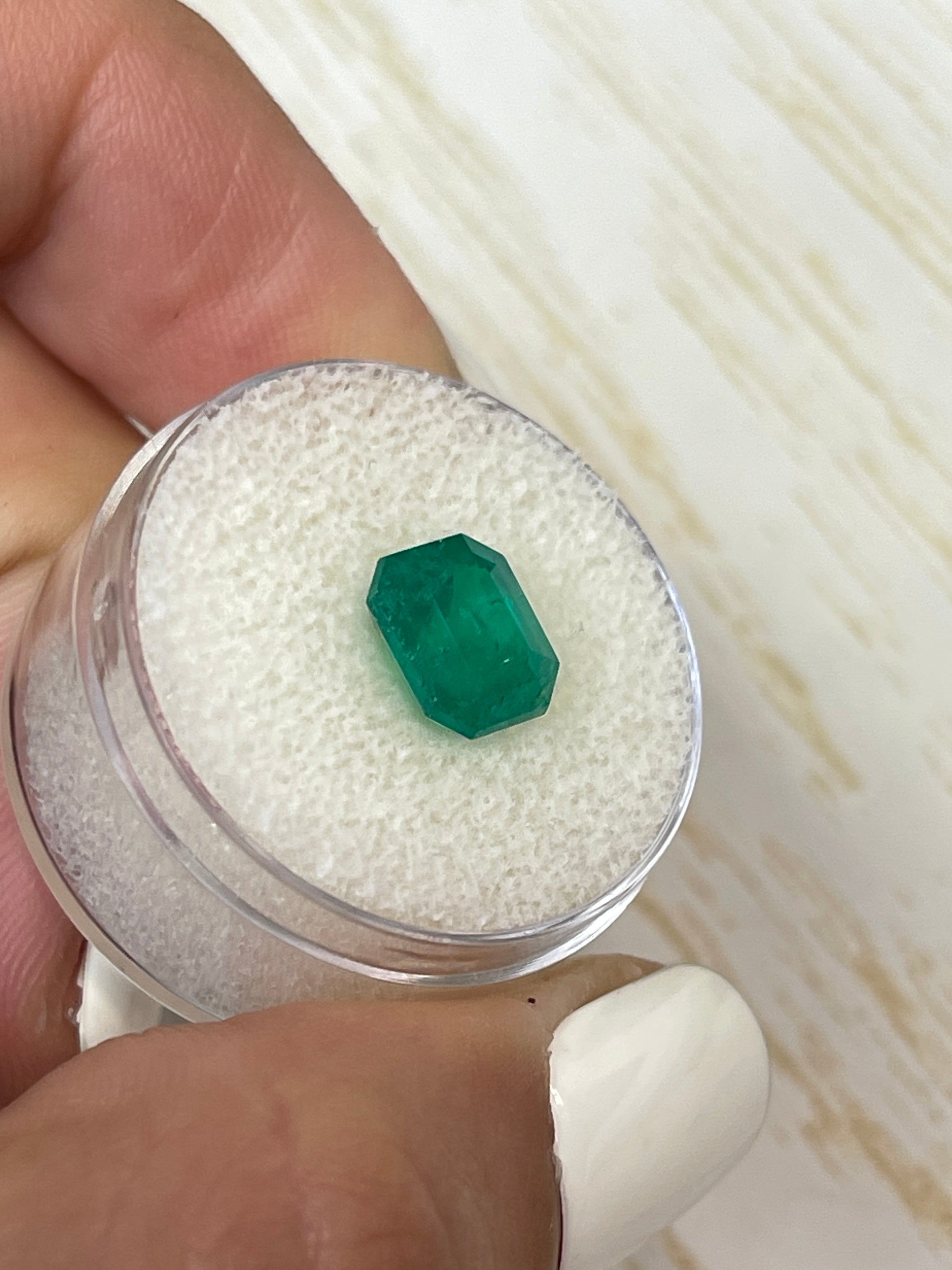 Deep bluish-green 2.74 carat natural Colombian emerald in an emerald cut, showcasing its vibrant color and clarity.