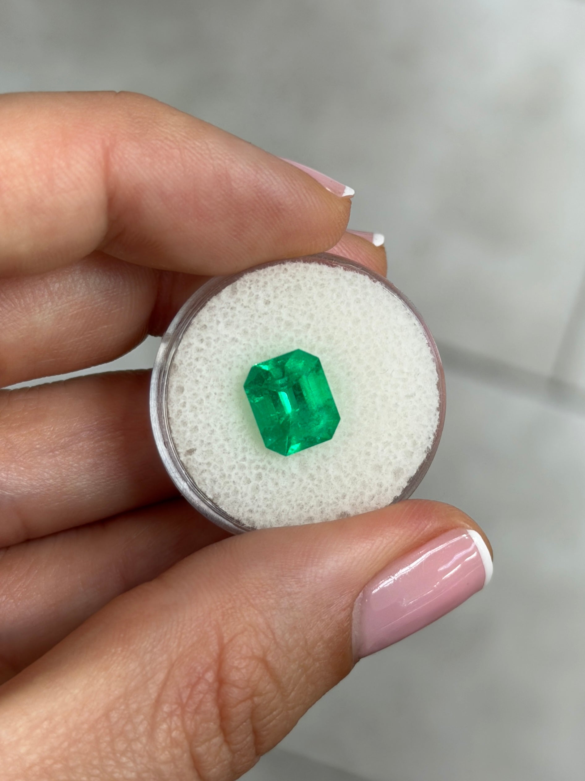 2.80 carat vivid green natural Colombian emerald loose gemstone in an emerald cut, displayed by JR Colombian Emeralds.