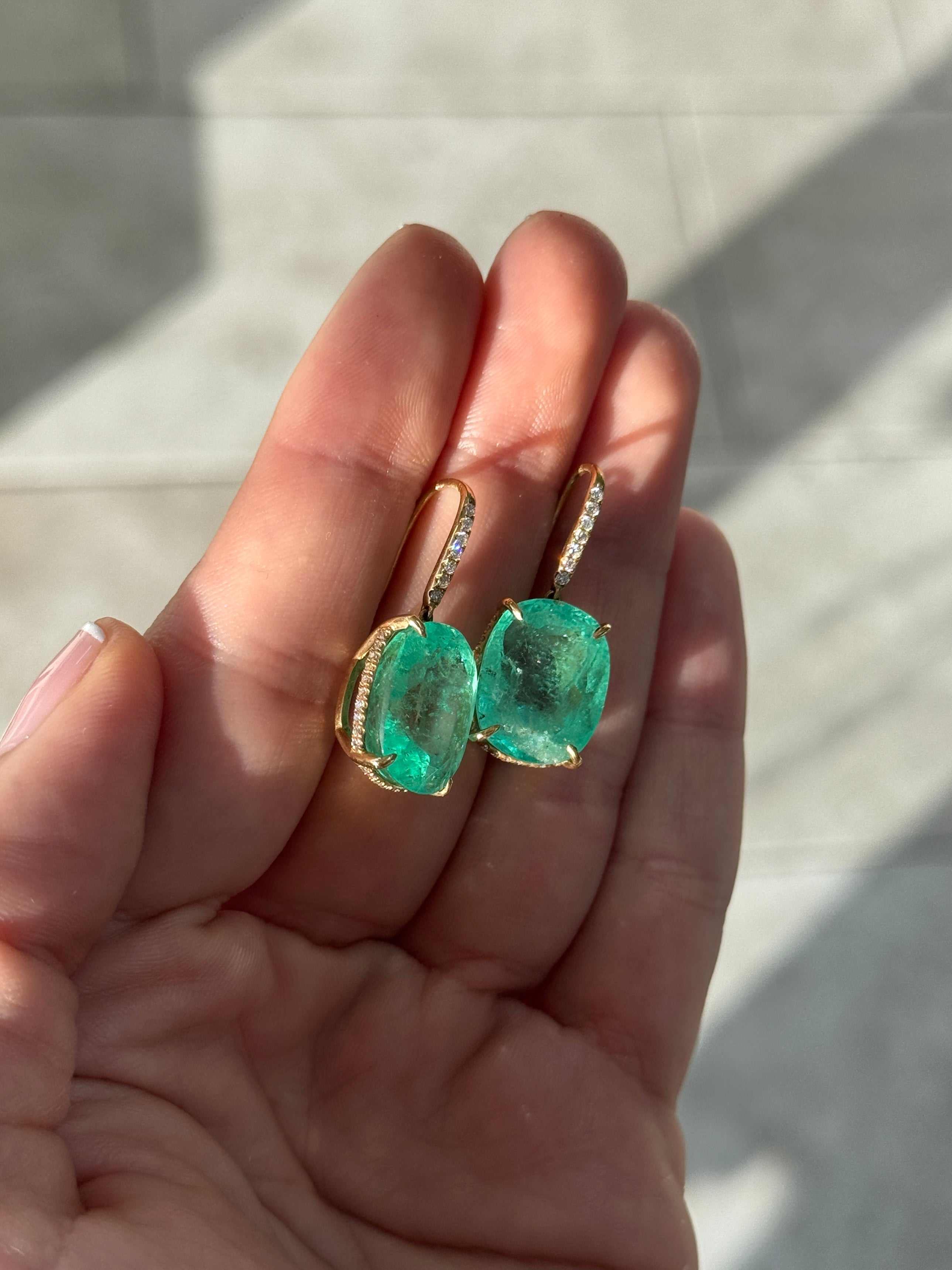 Large cushion cut Colombian emerald and diamond dangle earrings in 18K gold, featuring vibrant green emeralds and sparkling diamonds.