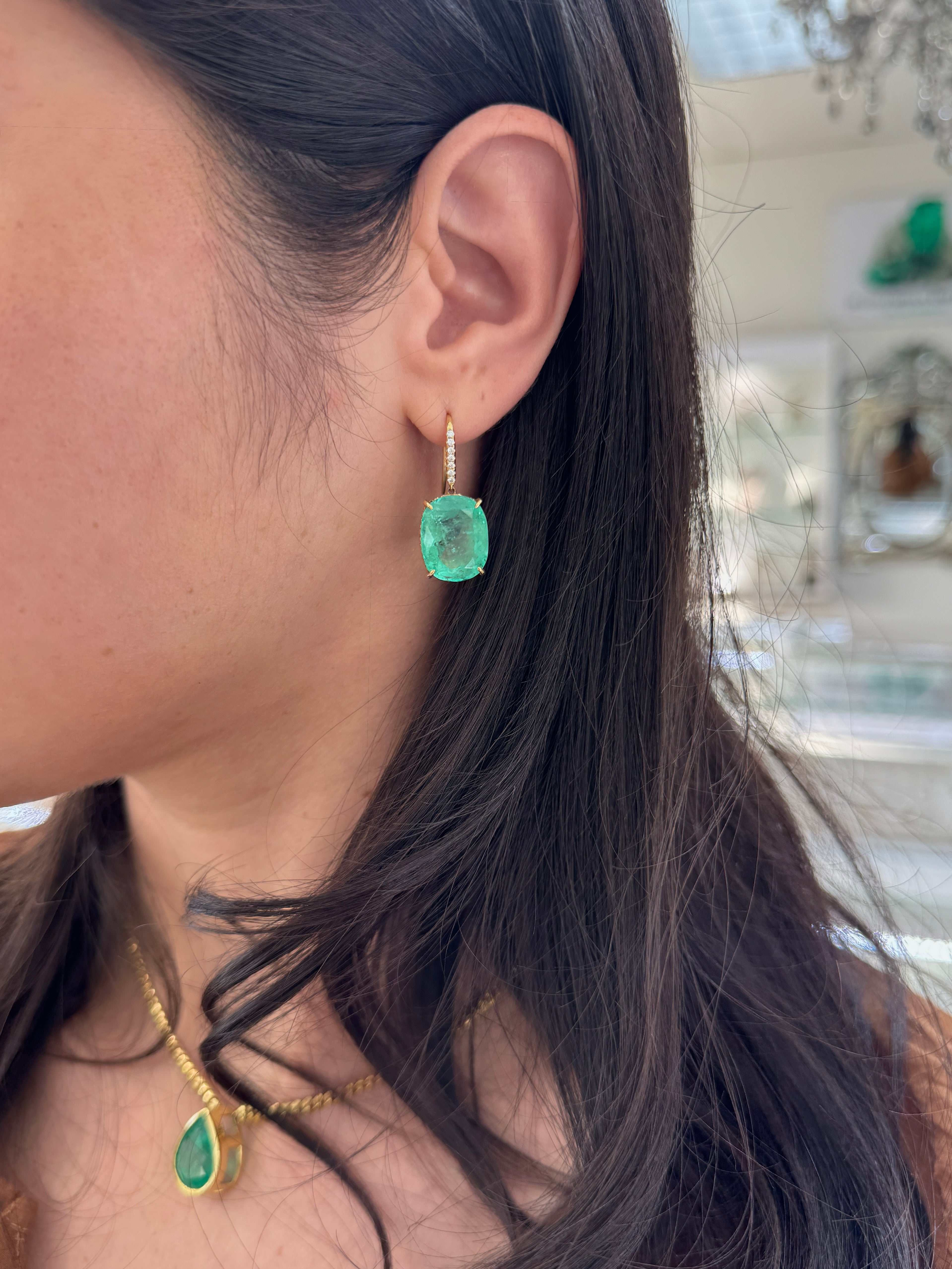 Large cushion cut Colombian emerald and diamond dangle earrings in 18K gold, featuring vibrant green emeralds and sparkling diamonds.