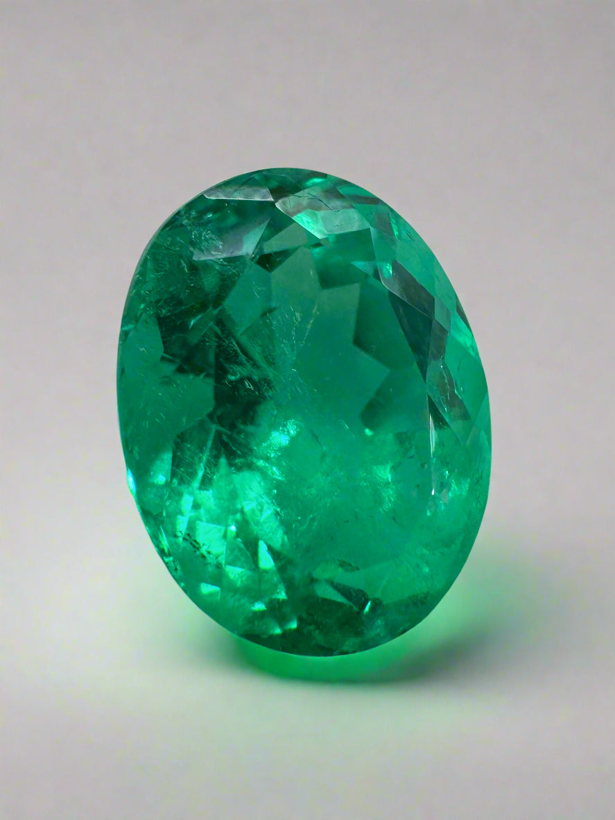 Vivid green 10x8mm oval Colombian emerald loose gemstone, ethically mined, displayed with reflection and natural light.