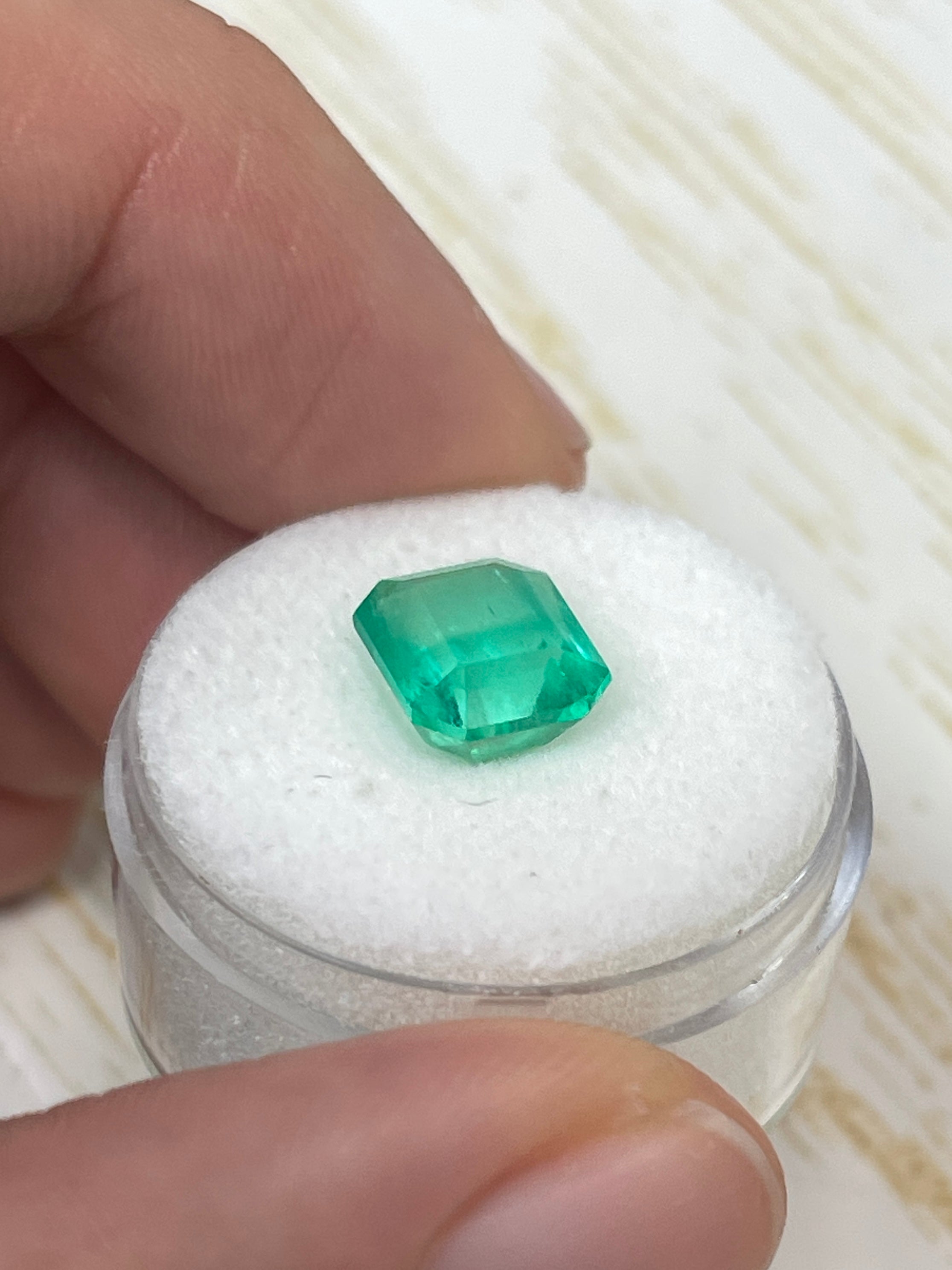 Electric yellowish Colombian emerald cut gemstone, 3.09 carats, from JR Colombian Emeralds, showcasing vibrant color and clarity.