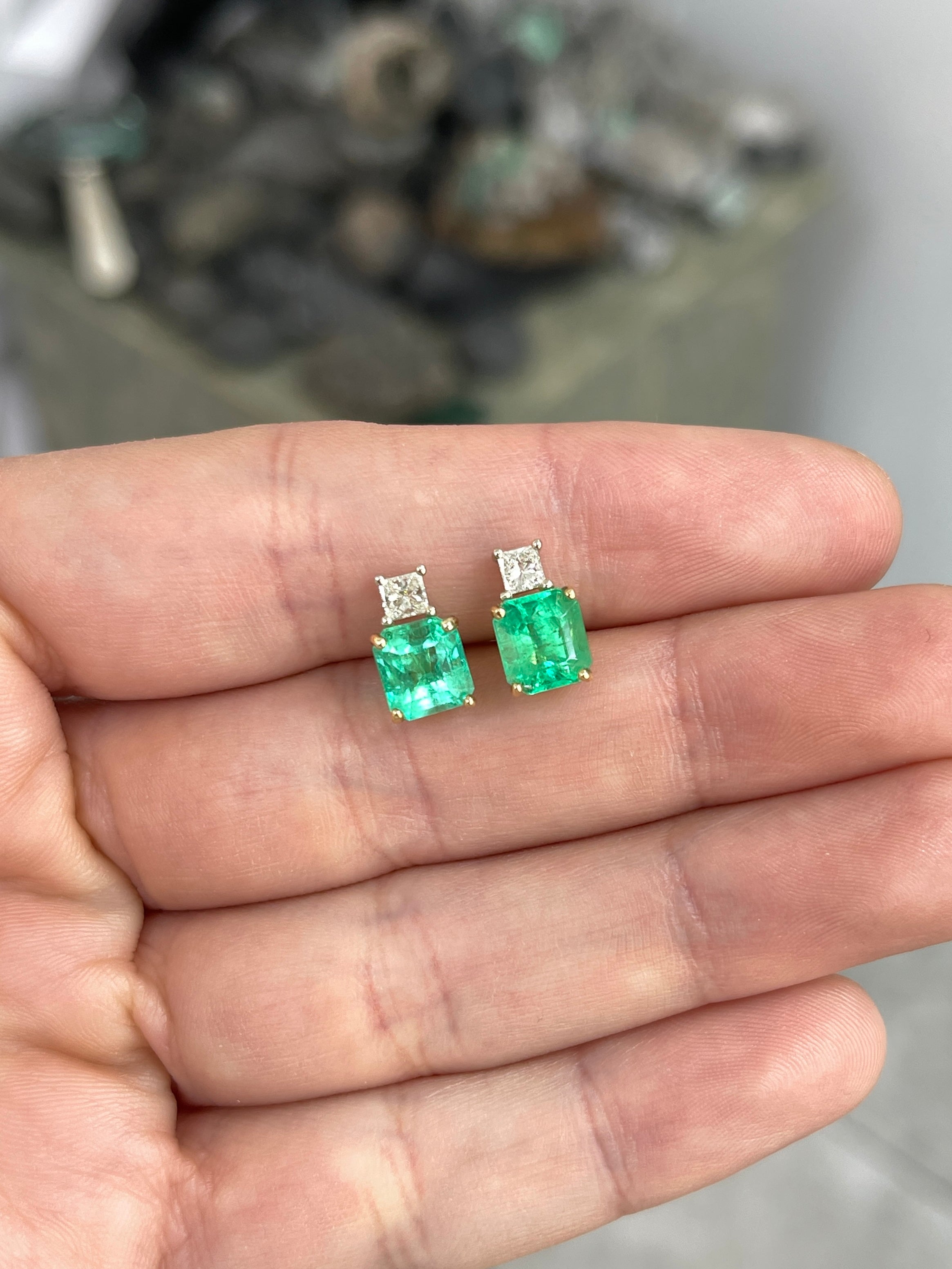 Colombian emerald and princess cut diamond earrings in 18K two-tone gold with vibrant green gemstones and sparkling diamonds.