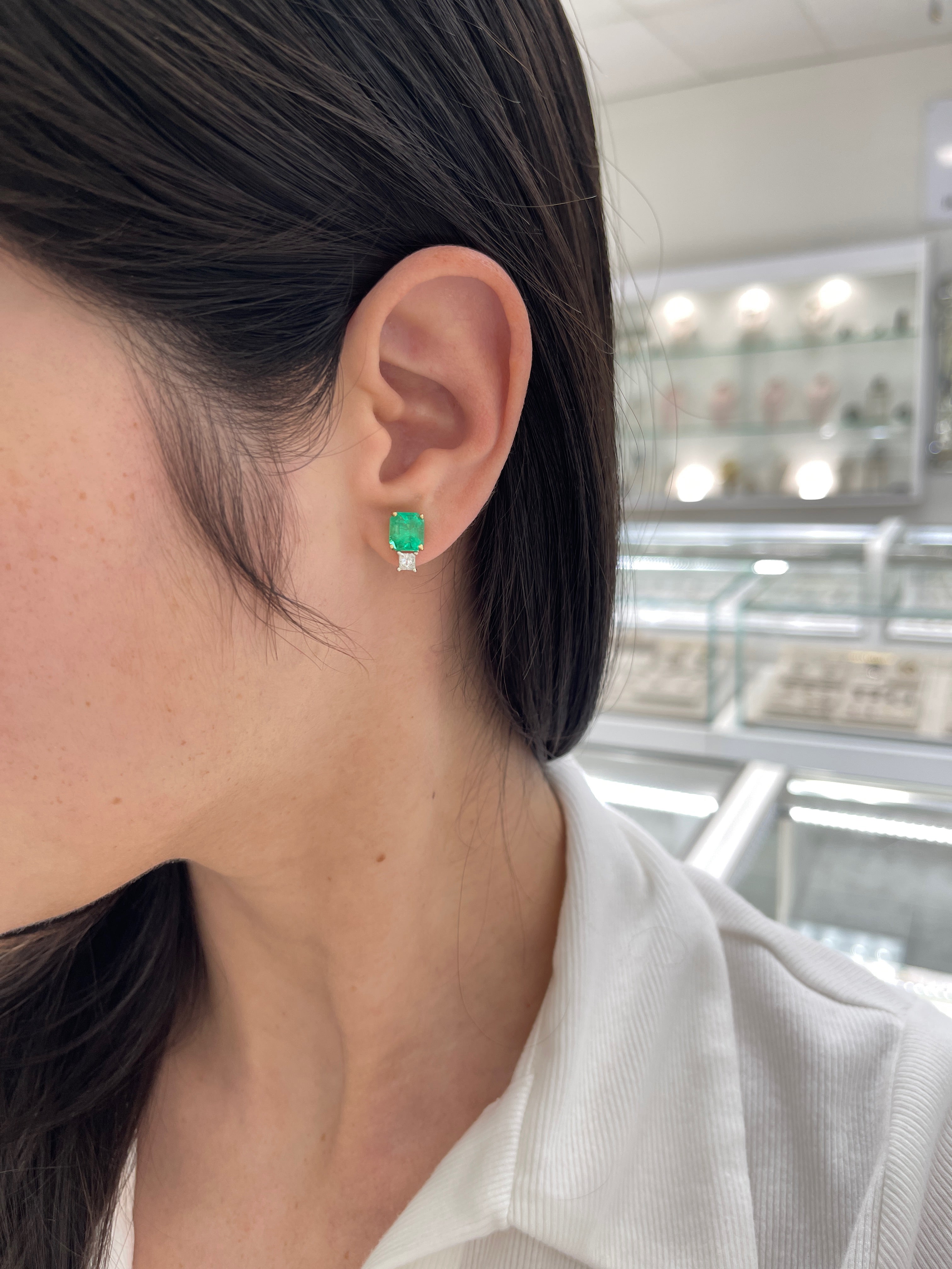 Colombian emerald and princess cut diamond earrings in 18K two-tone gold, featuring vibrant green emeralds and sparkling diamonds.