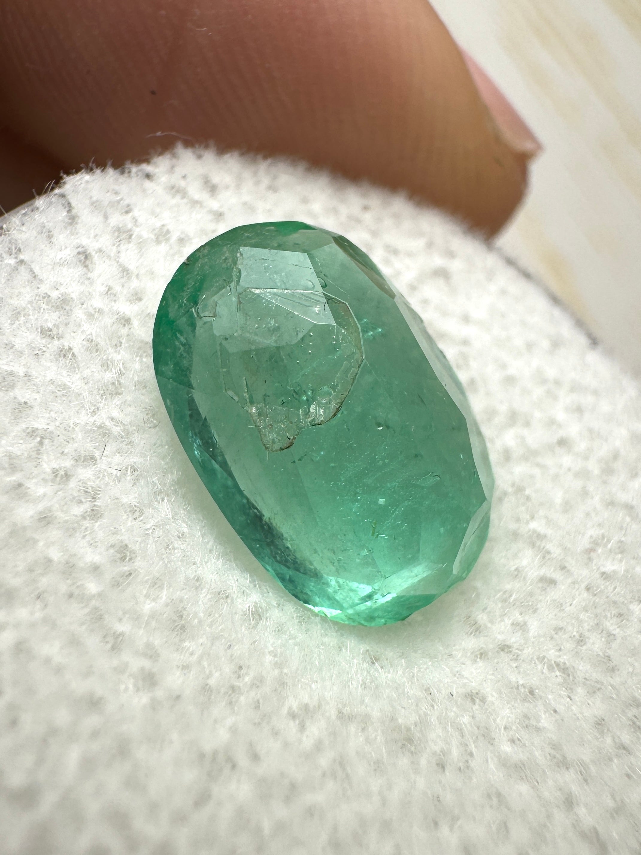 3.25 carat natural Colombian emerald loose oval cut gemstone with vibrant green color, displayed by JR Colombian Emeralds.