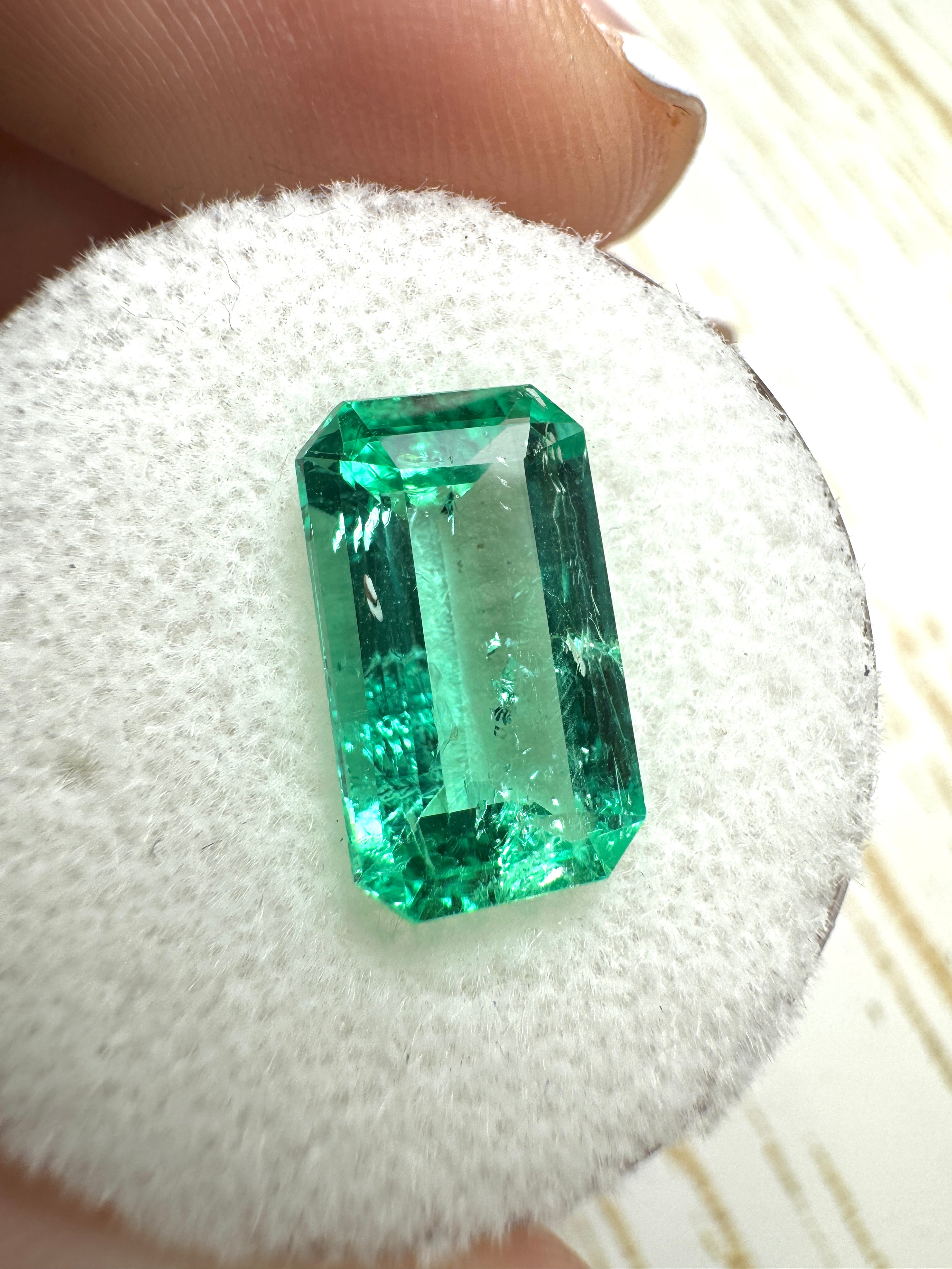 Elongated 3.42 carat natural Colombian emerald loose gemstone with emerald cut, glowing vibrant green from JR Colombian Emeralds