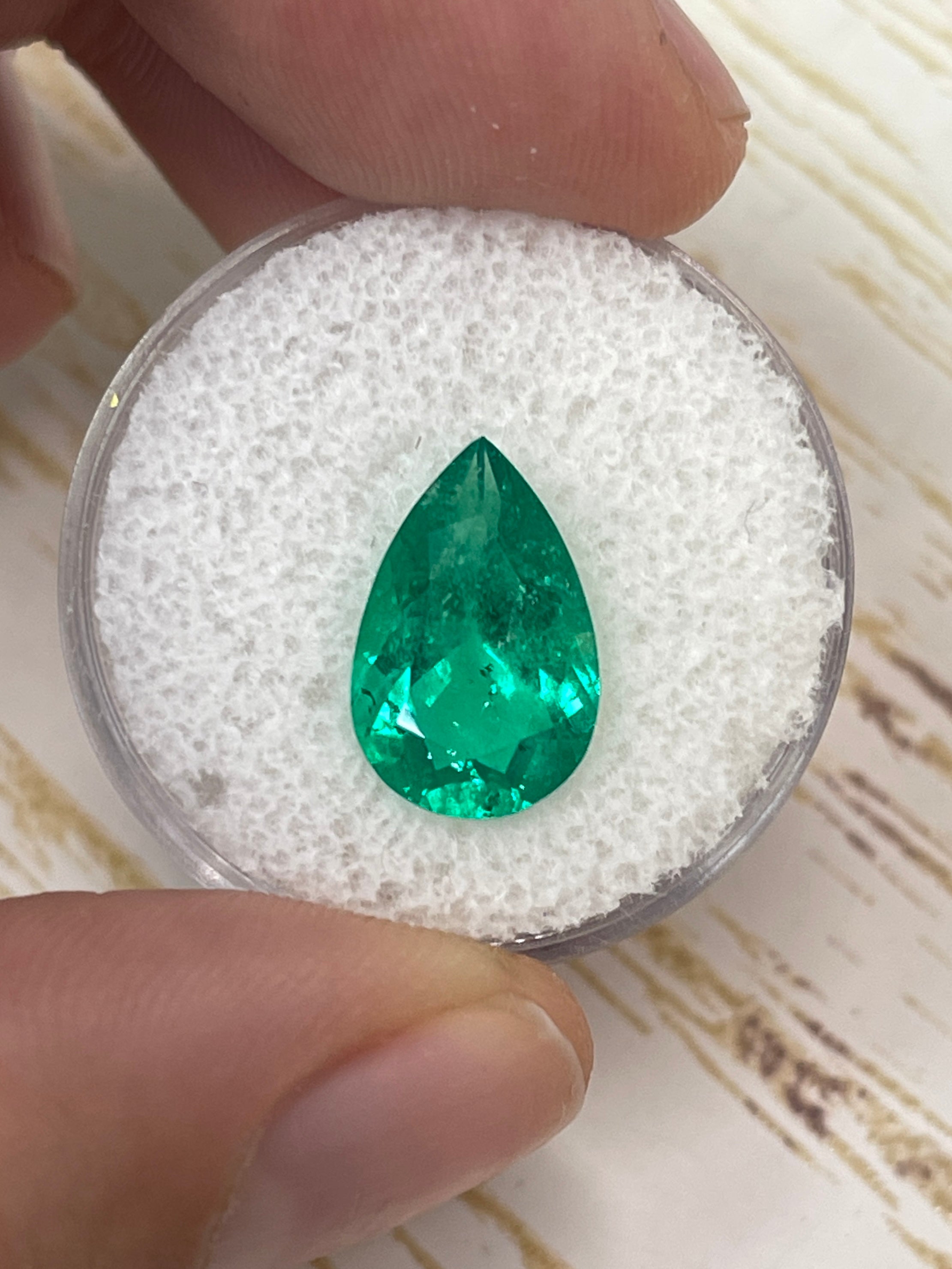 3.47 carat 14x9mm pear-shaped natural Colombian Muzo emerald from JR Colombian Emeralds, loose gemstone on white background.