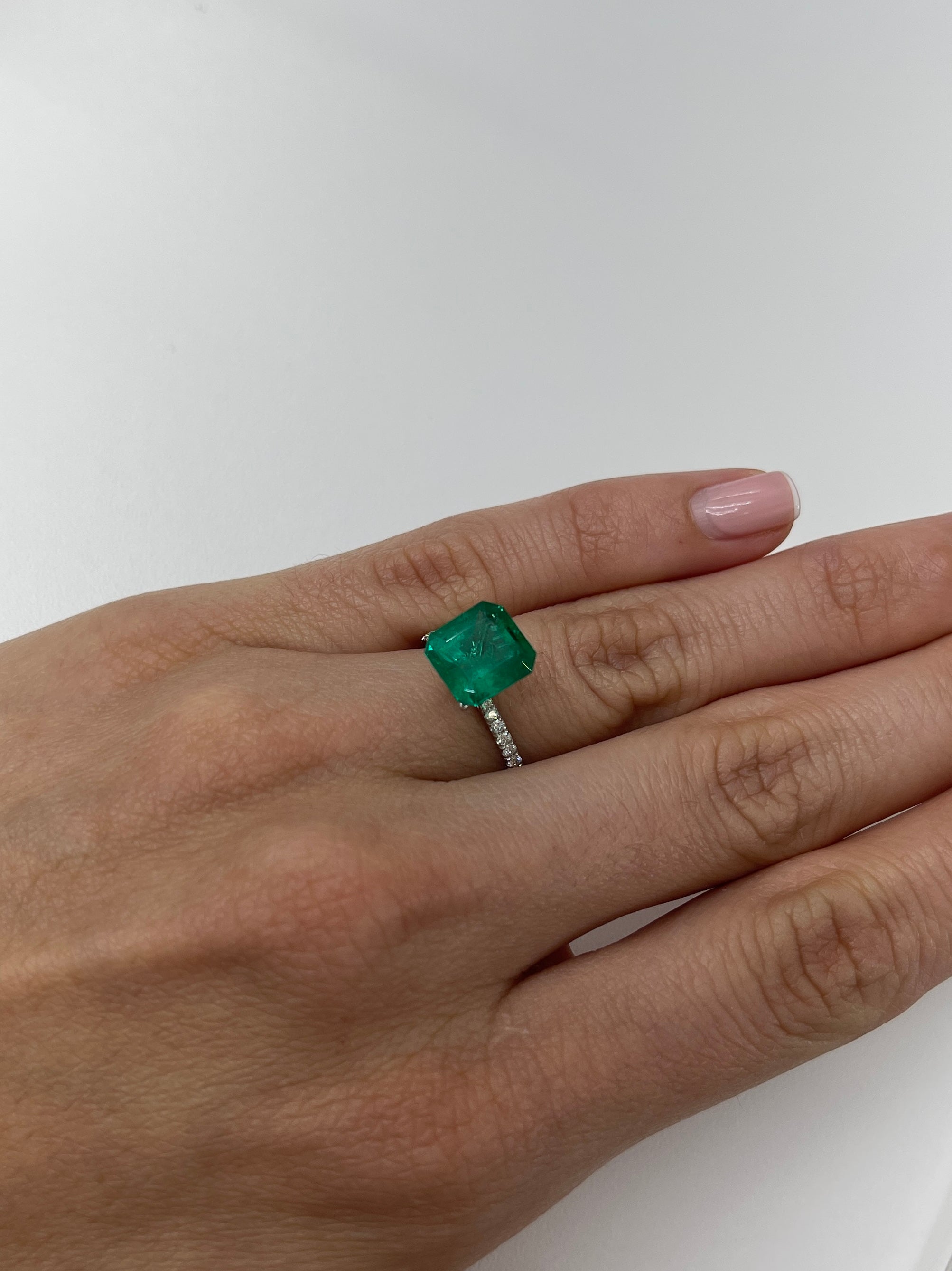 Vivid 3.49 carat Muzo green Colombian emerald loose in an emerald cut, showcasing its natural, vibrant green color.