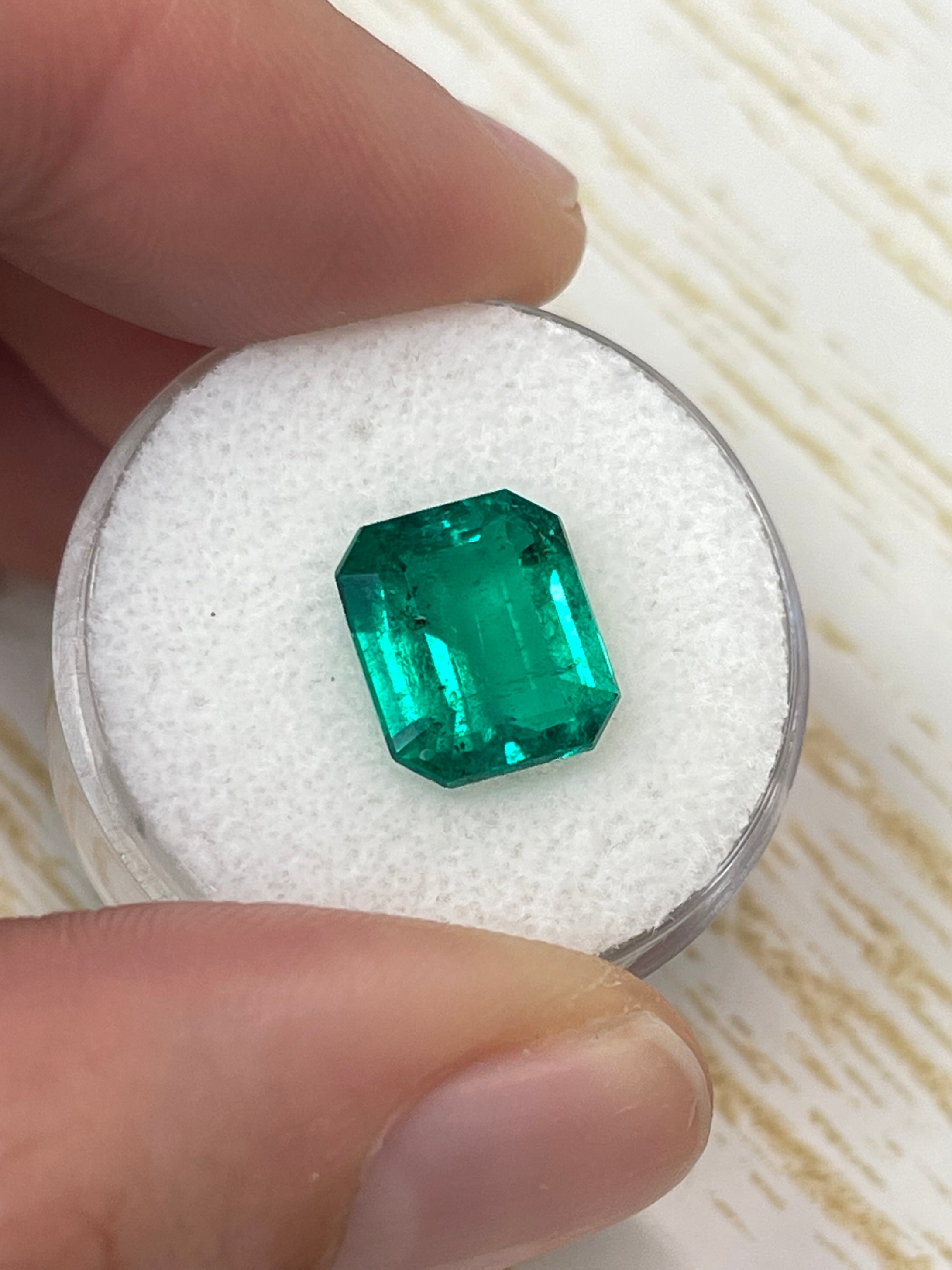 AAA+ 3.72 carat natural Colombian emerald loose gemstone with green color and freckled pattern, cut in an emerald shape by JR Colombian Emeralds.
