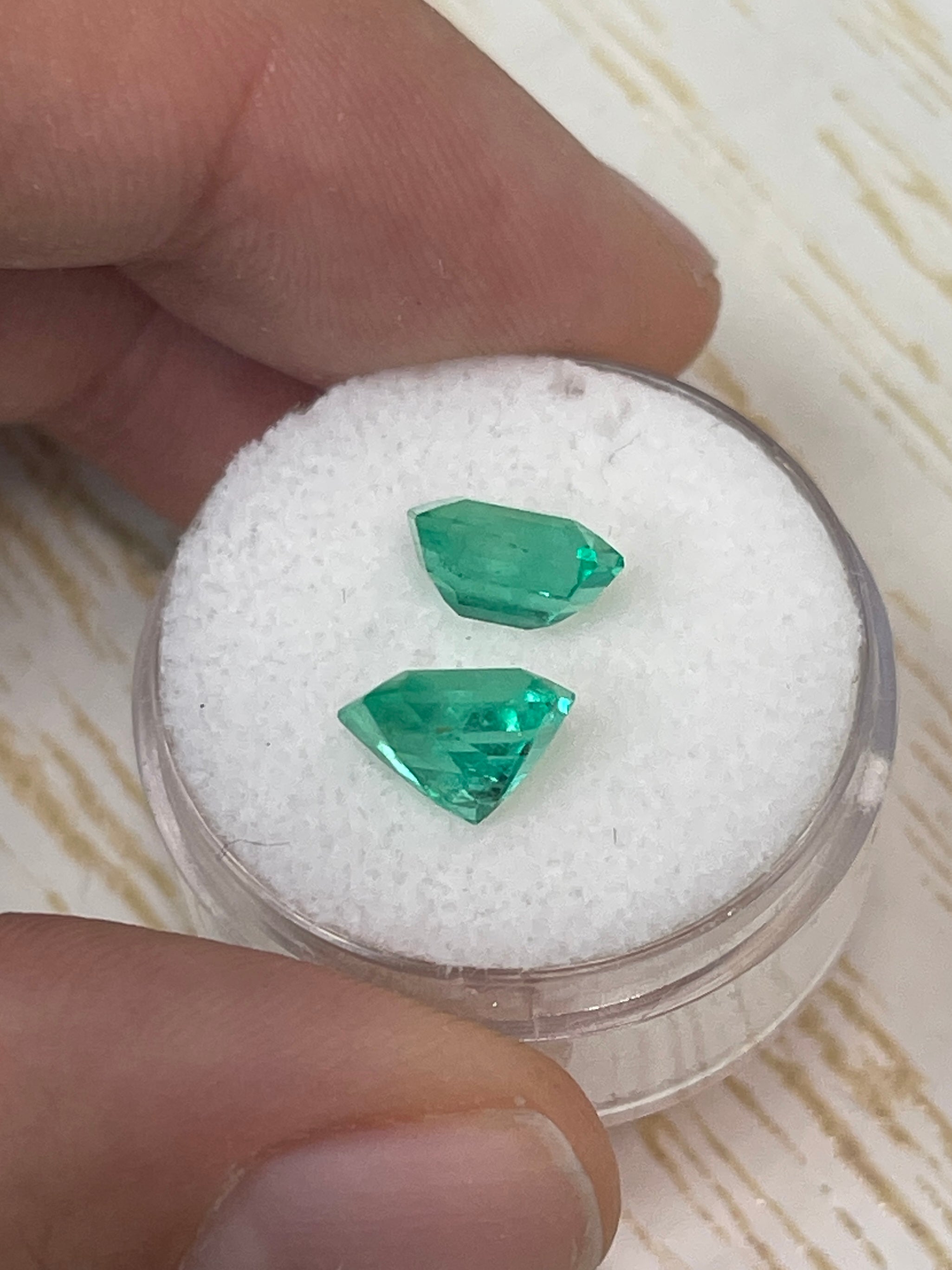 Three 3.73tcw matching green Colombian emeralds in emerald cut, loose gemstones showcasing vibrant color and clarity.