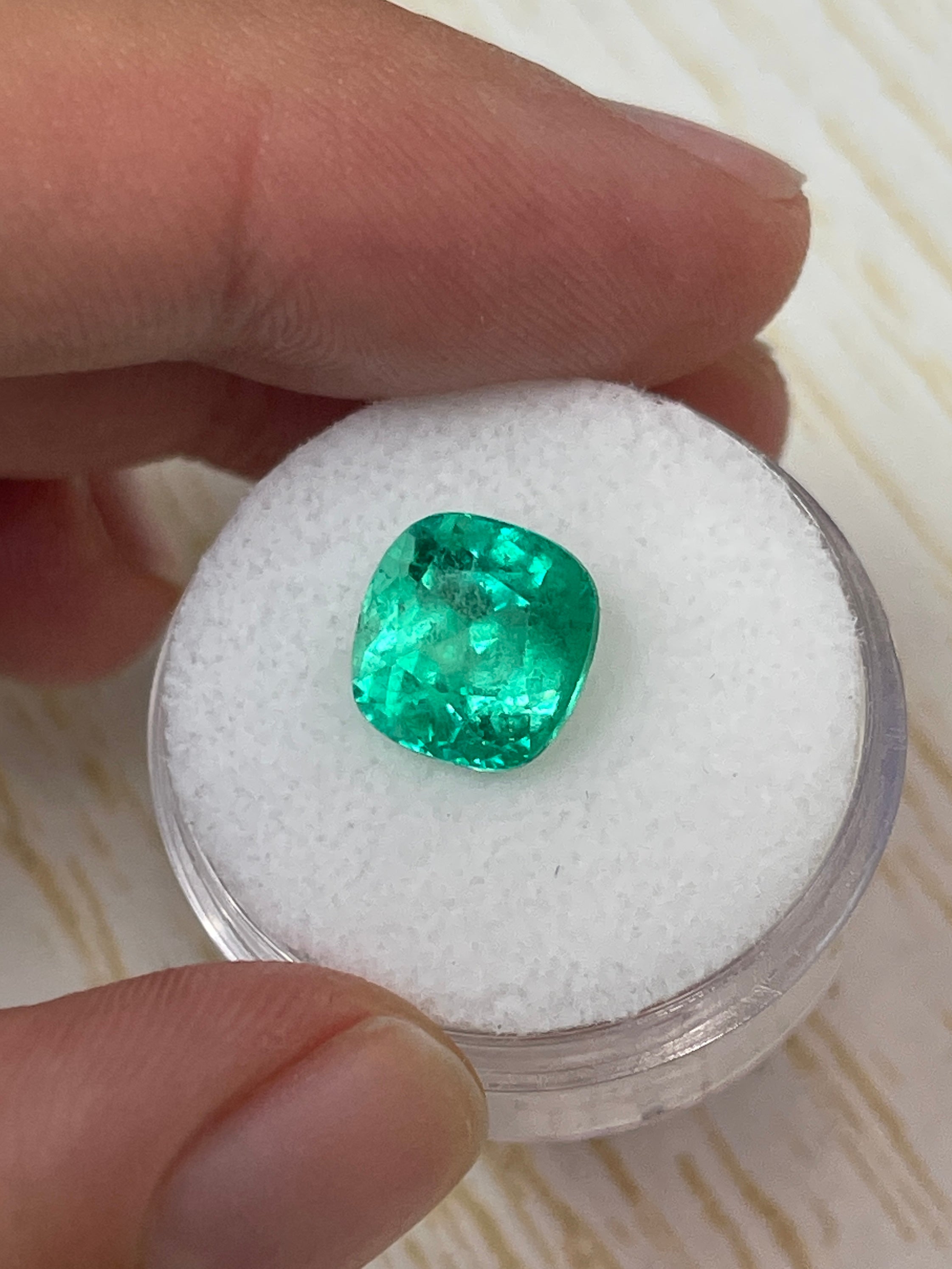 Bright yellowish green 3.85 carat natural Colombian emerald in cushion cut, showcasing vibrant color and clarity.