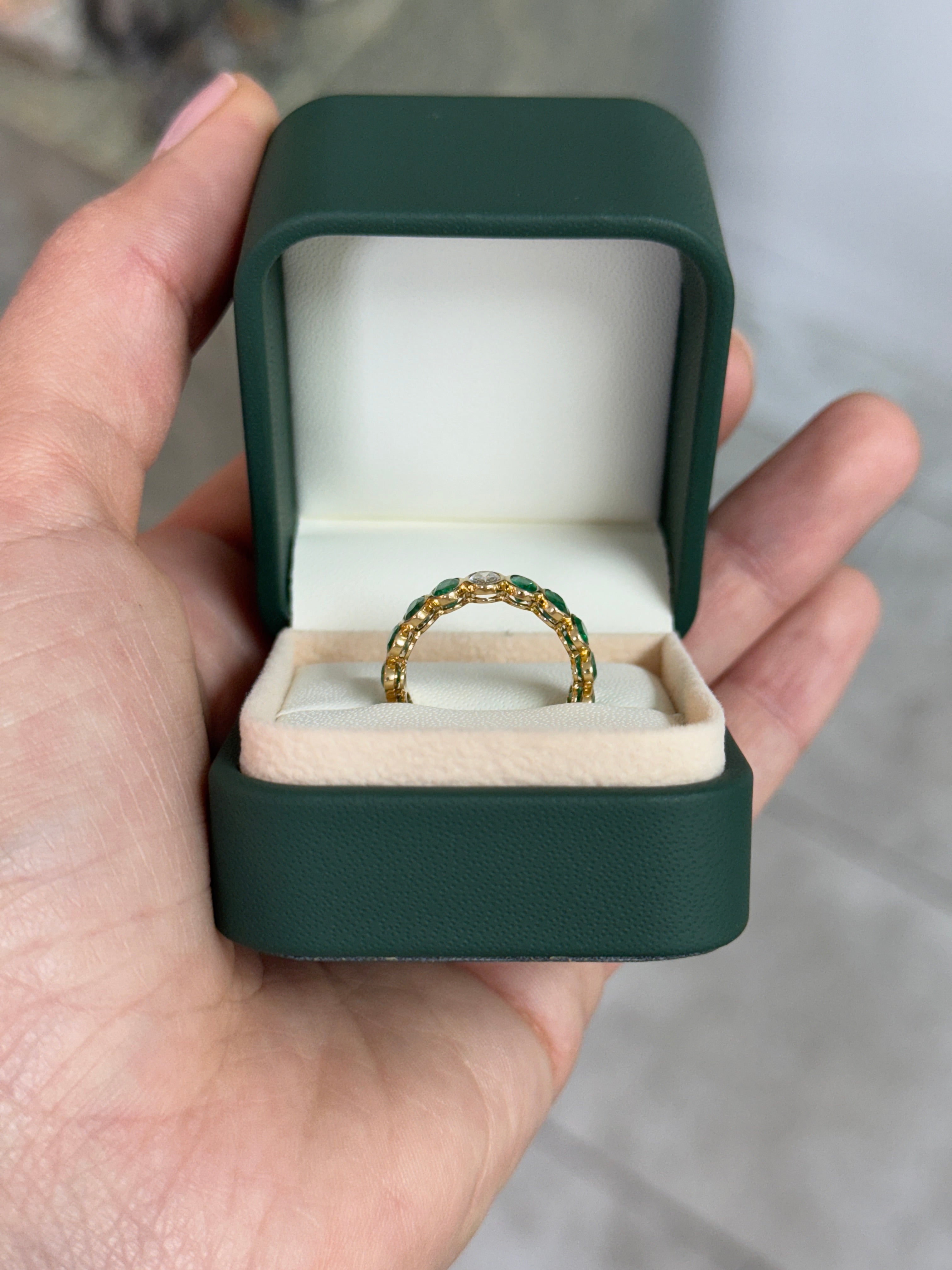 JR Colombian Emeralds 3.86tcw bezel set oval emerald and diamond eternity band in size 6.5, showcasing fine craftsmanship and sparkling gemstones.