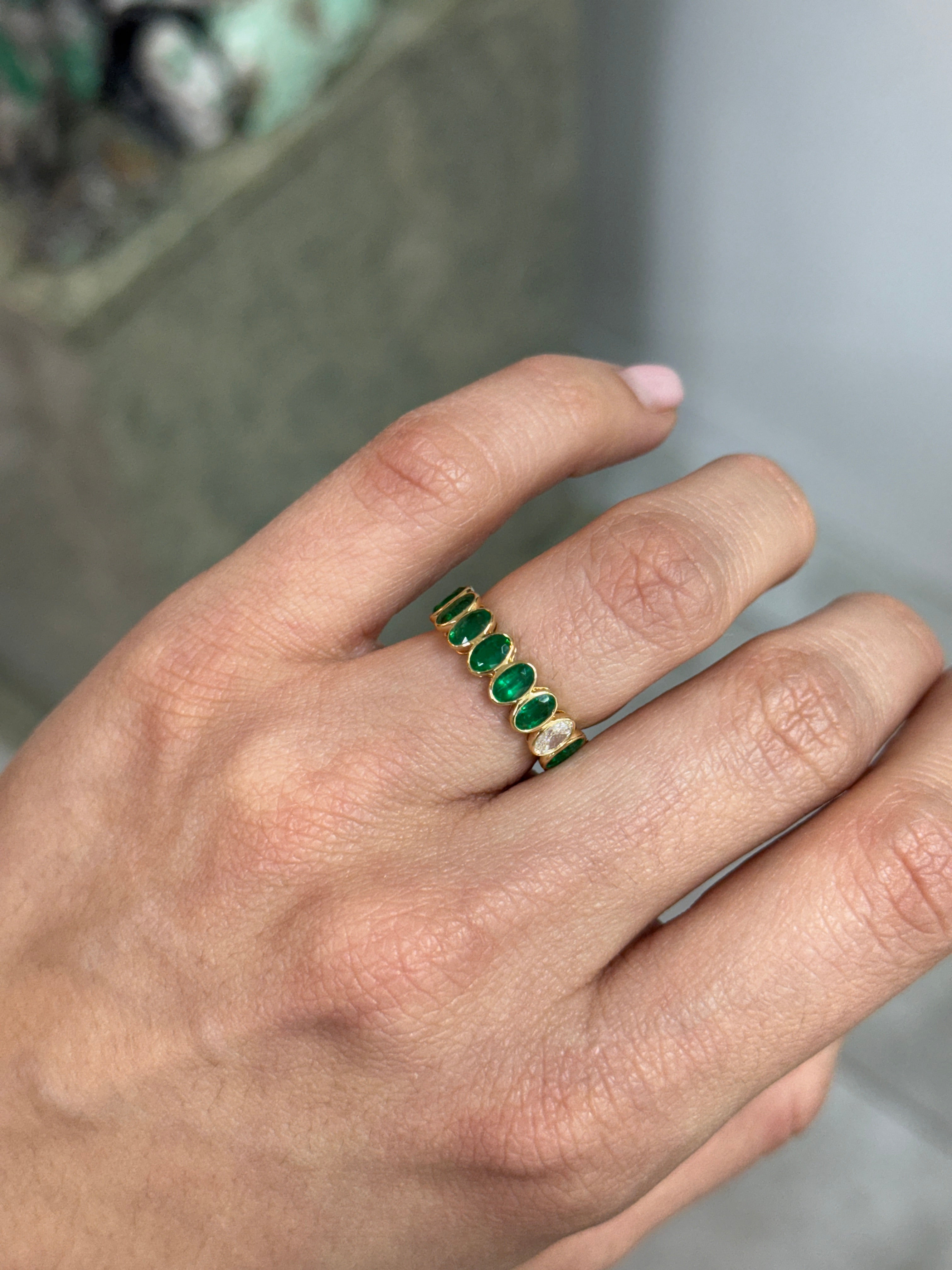 JR Colombian Emeralds 3.86tcw bezel set oval emerald and diamond eternity band in size 6.5, showcasing luxurious gemstone craftsmanship.