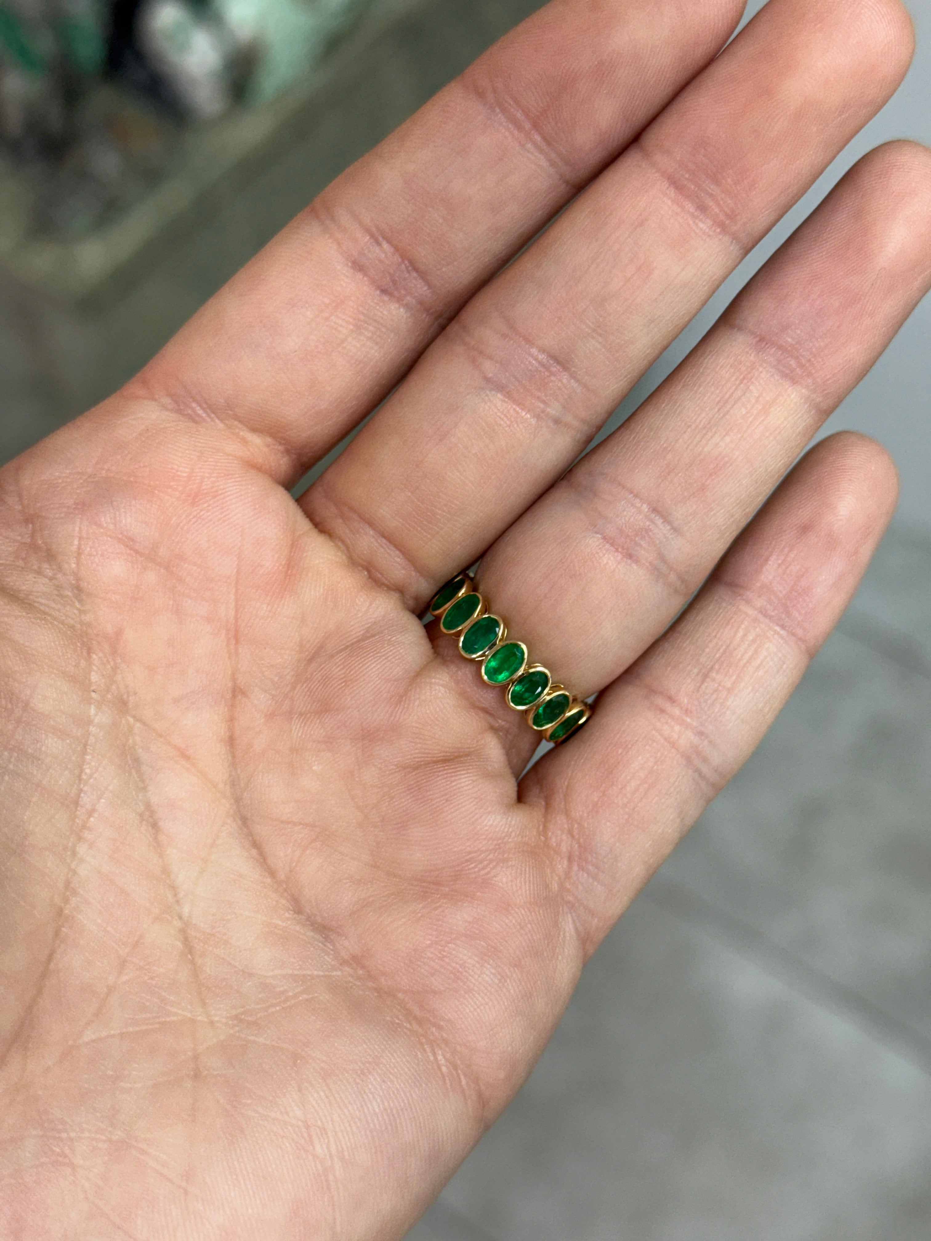 JR Colombian Emeralds 3.86tcw bezel set oval emerald and diamond eternity band in size 6.5, featuring alternating gemstones in a sleek design.