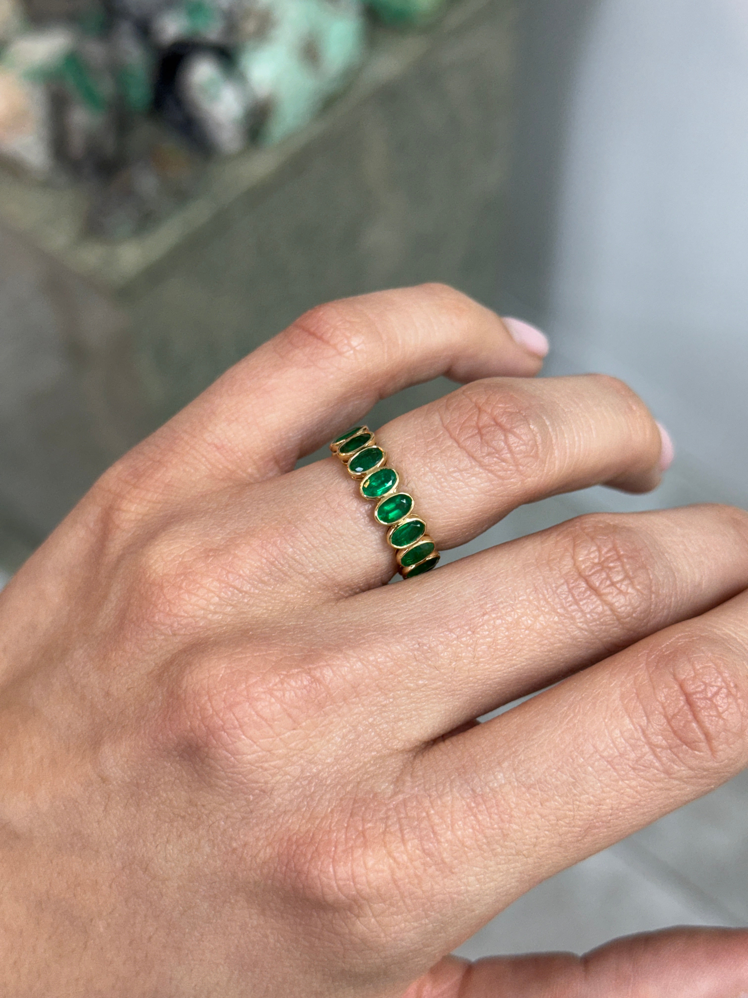JR Colombian Emeralds 3.86tcw bezel set oval emerald and diamond eternity band in size 6.5, showcasing fine jewelry craftsmanship.