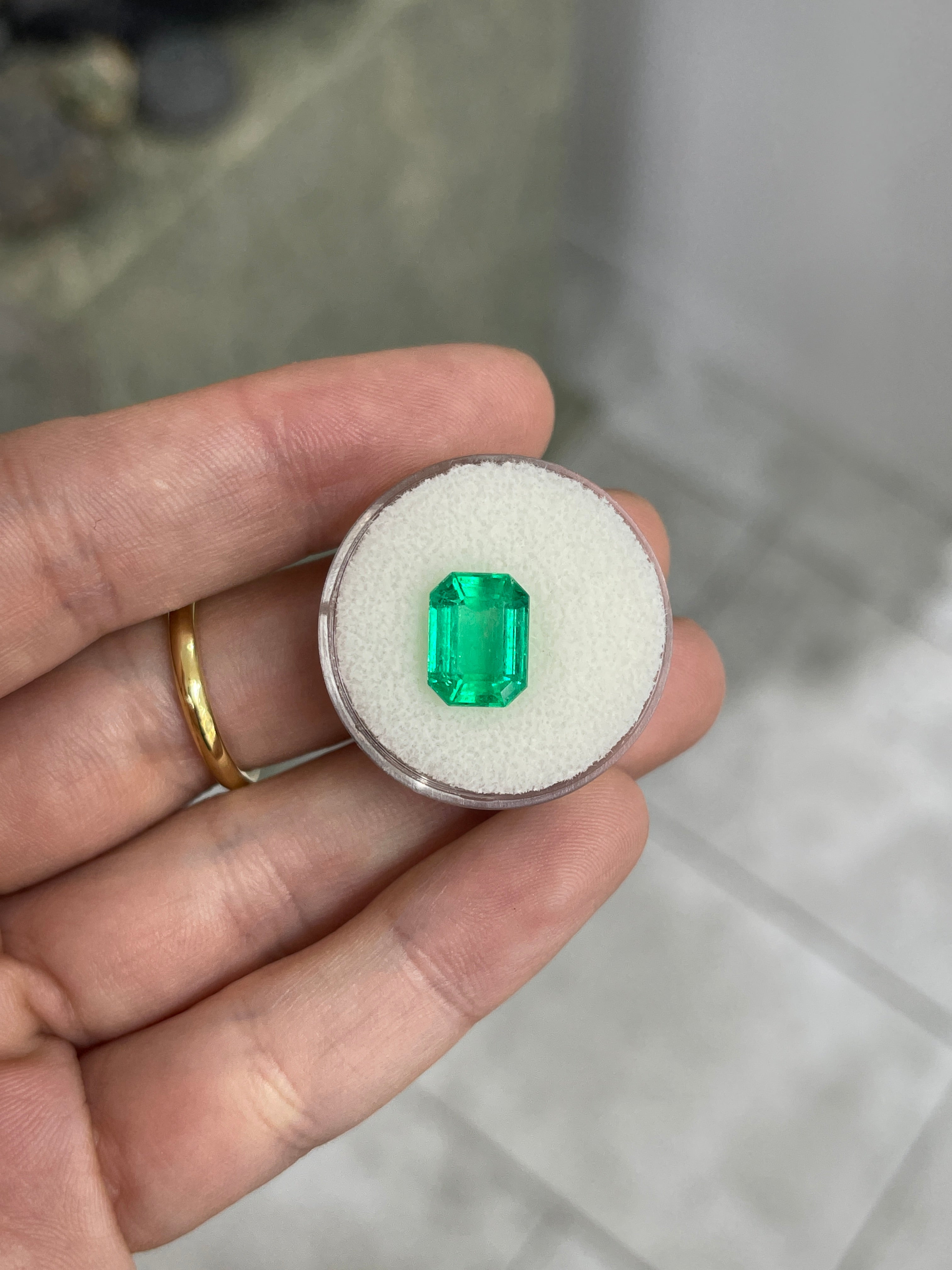 Natural 3.88 carat green Colombian emerald loose gemstone in an emerald cut, showcasing vibrant, glowing green color.