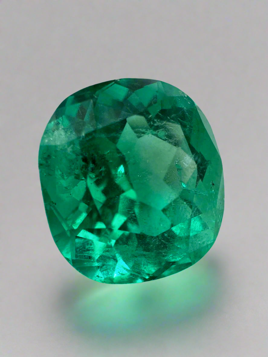 4.96 Carat freckled vivid bluish green cushion cut loose emerald by JR Colombian Emeralds, showcasing rich color and natural inclusions.