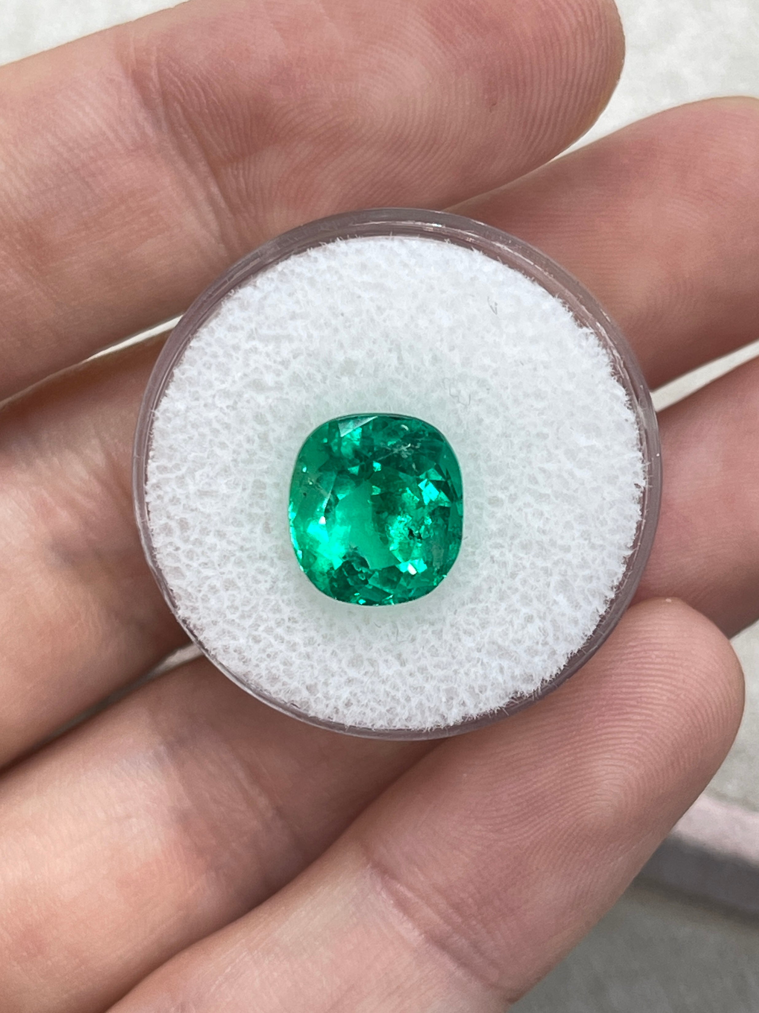 Vivid bluish green 4.96 carat cushion cut loose emerald with natural freckles, from JR Colombian Emeralds.