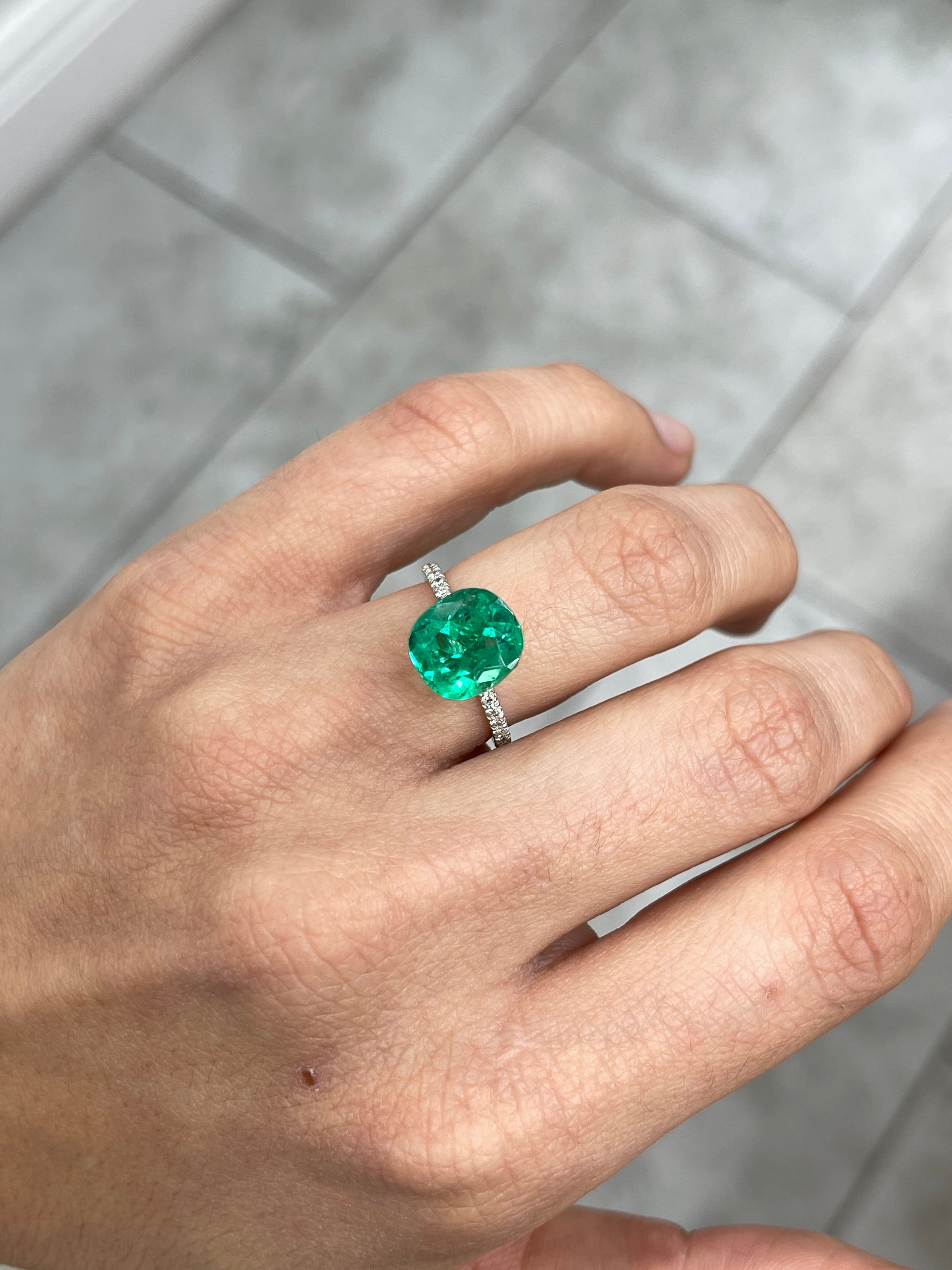 Fourteen 4.96 carat freckled vivid bluish green cushion cut loose emerald from JR Colombian Emeralds with natural inclusions.