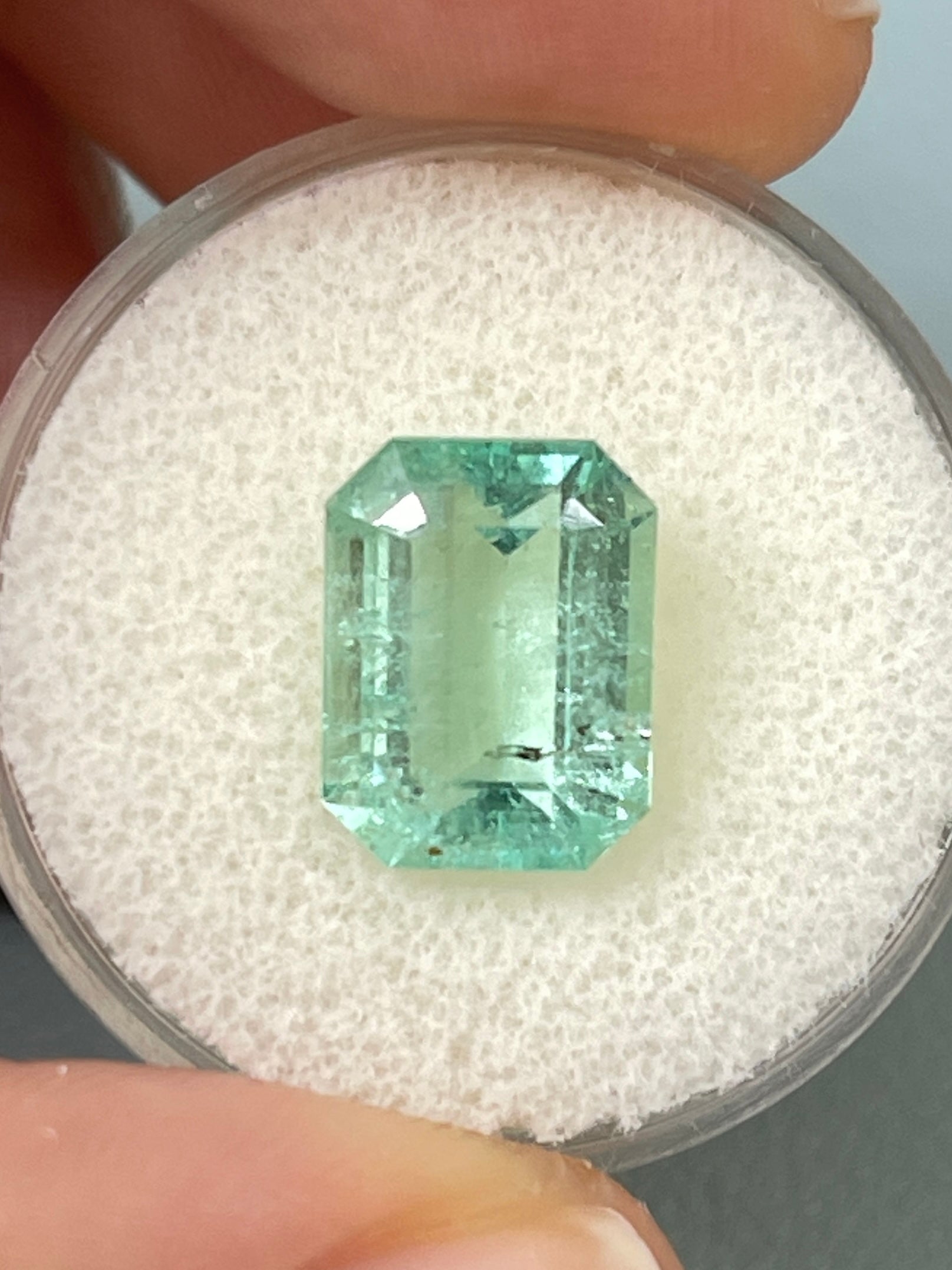 4.06 carat light green Colombian emerald loose gemstone, 11x9 mm classic emerald cut with natural freckles, from JR Colombian Emeralds.