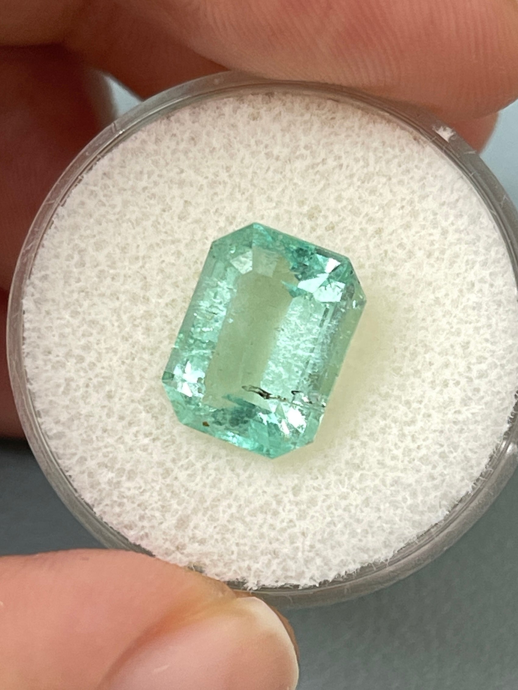 Light green 4.06 carat Colombian emerald loose gemstone in classic emerald cut with natural freckles, from JR Colombian Emeralds.