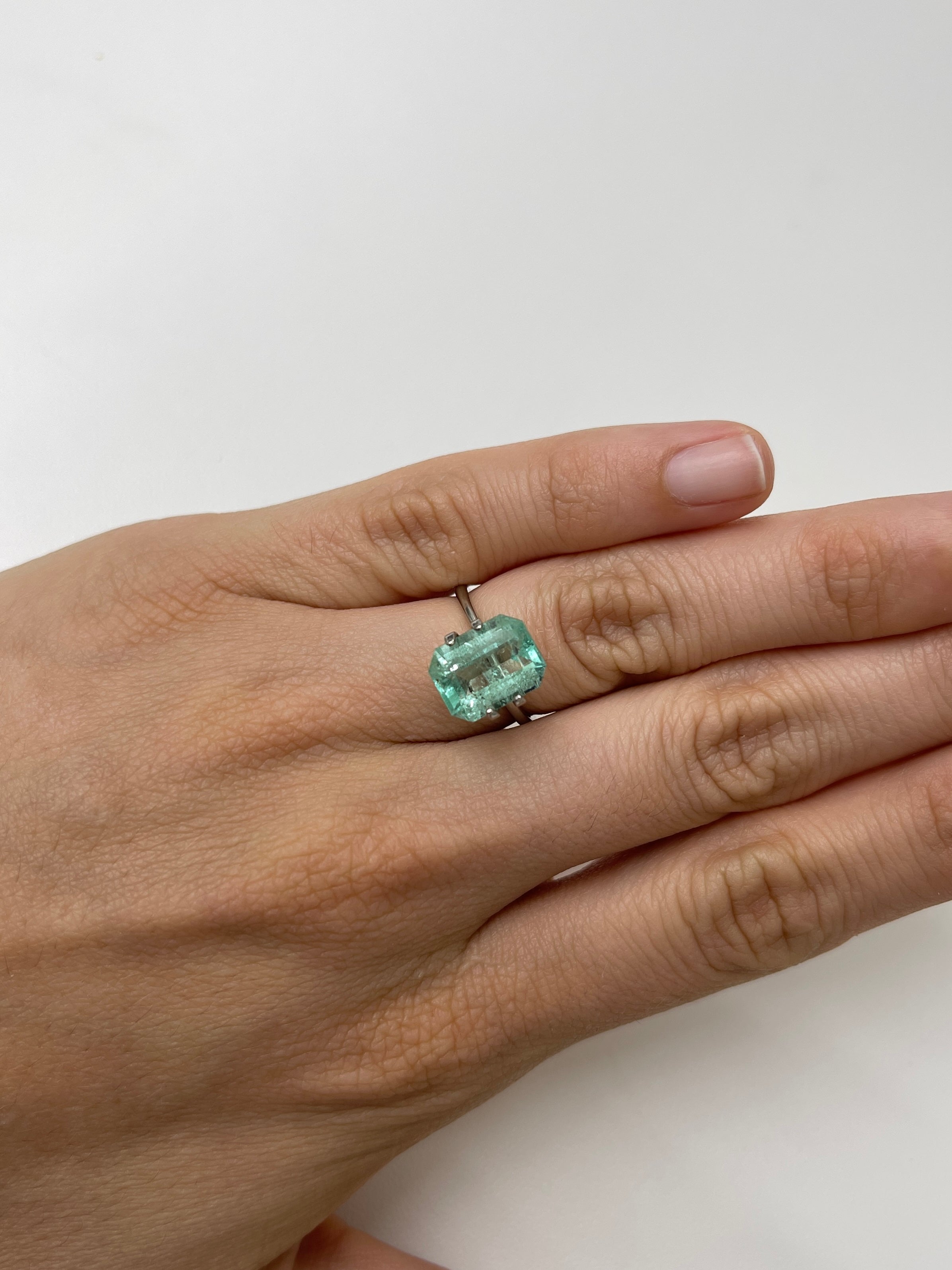 Light green 4.06 carat Colombian emerald loose gemstone with natural freckles, classic emerald cut, from JR Colombian Emeralds.