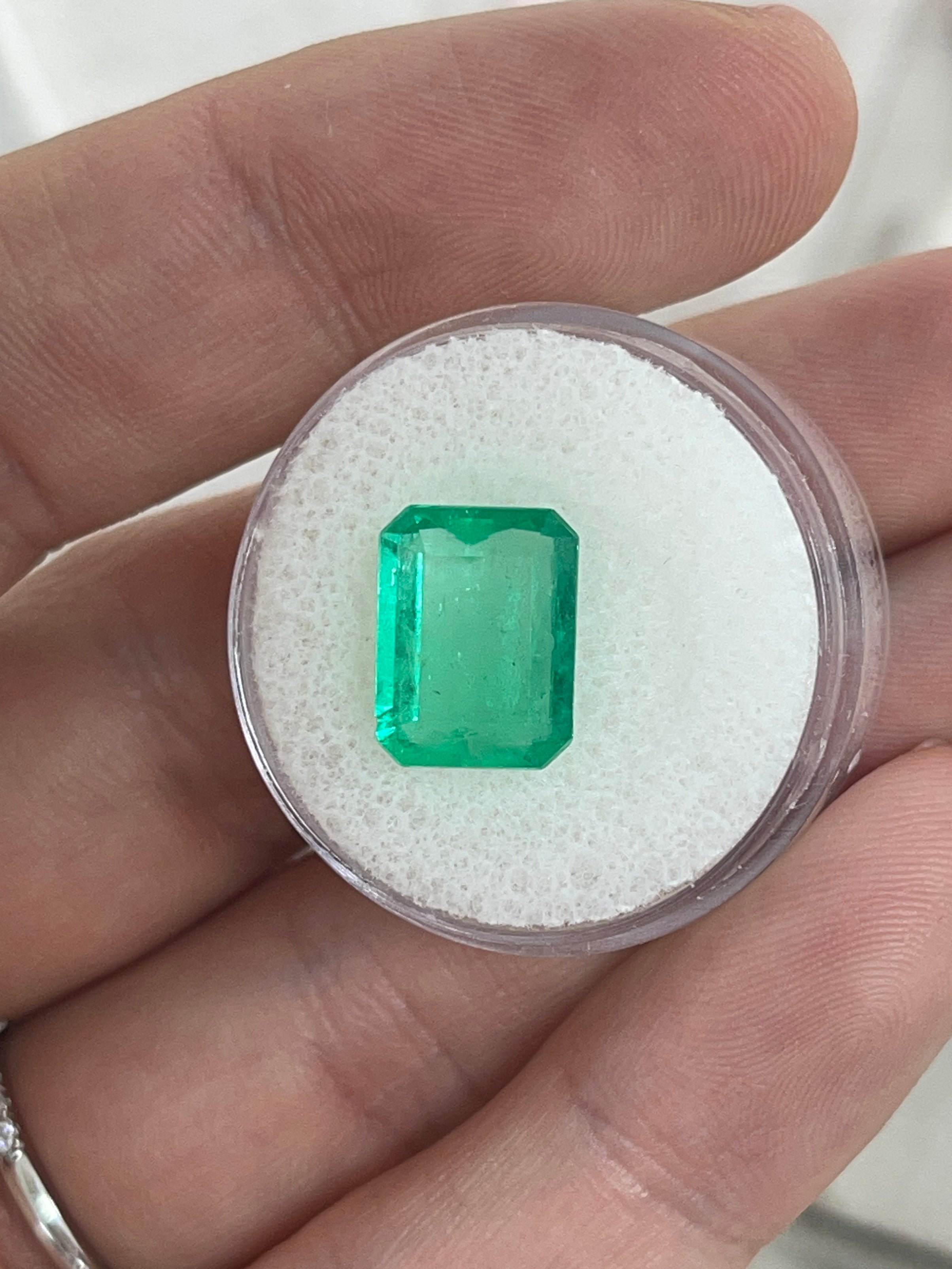 4.12 carat natural Colombian emerald loose gemstone in 12x9mm portrait cut, showcasing vibrant green color and emerald cut facets.