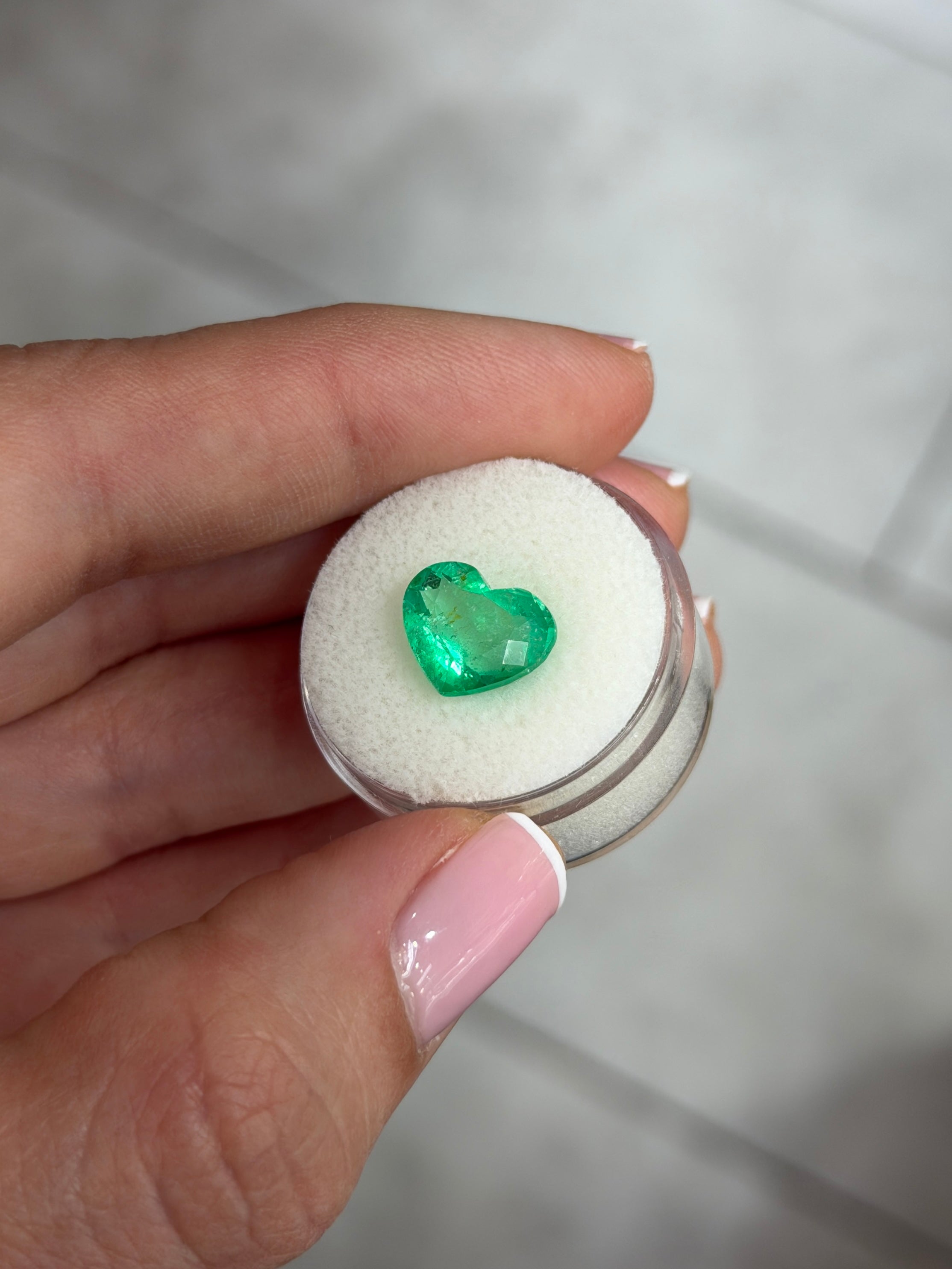Bright green 4.40 carat natural Colombian emerald in heart cut, showcasing vibrant color and clarity.