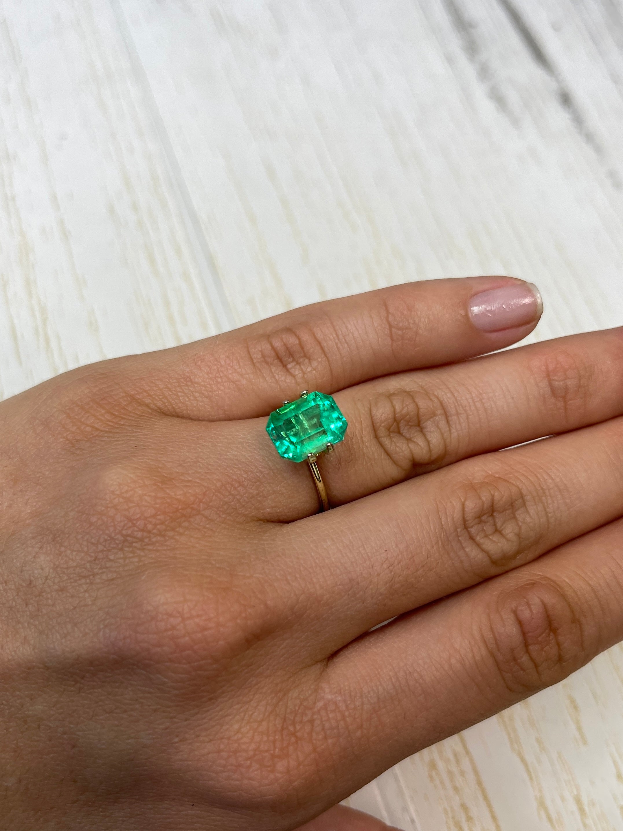 4.70 carat yellowish green natural Colombian emerald loose gemstone in classic emerald cut, showcasing its vibrant color and clarity.