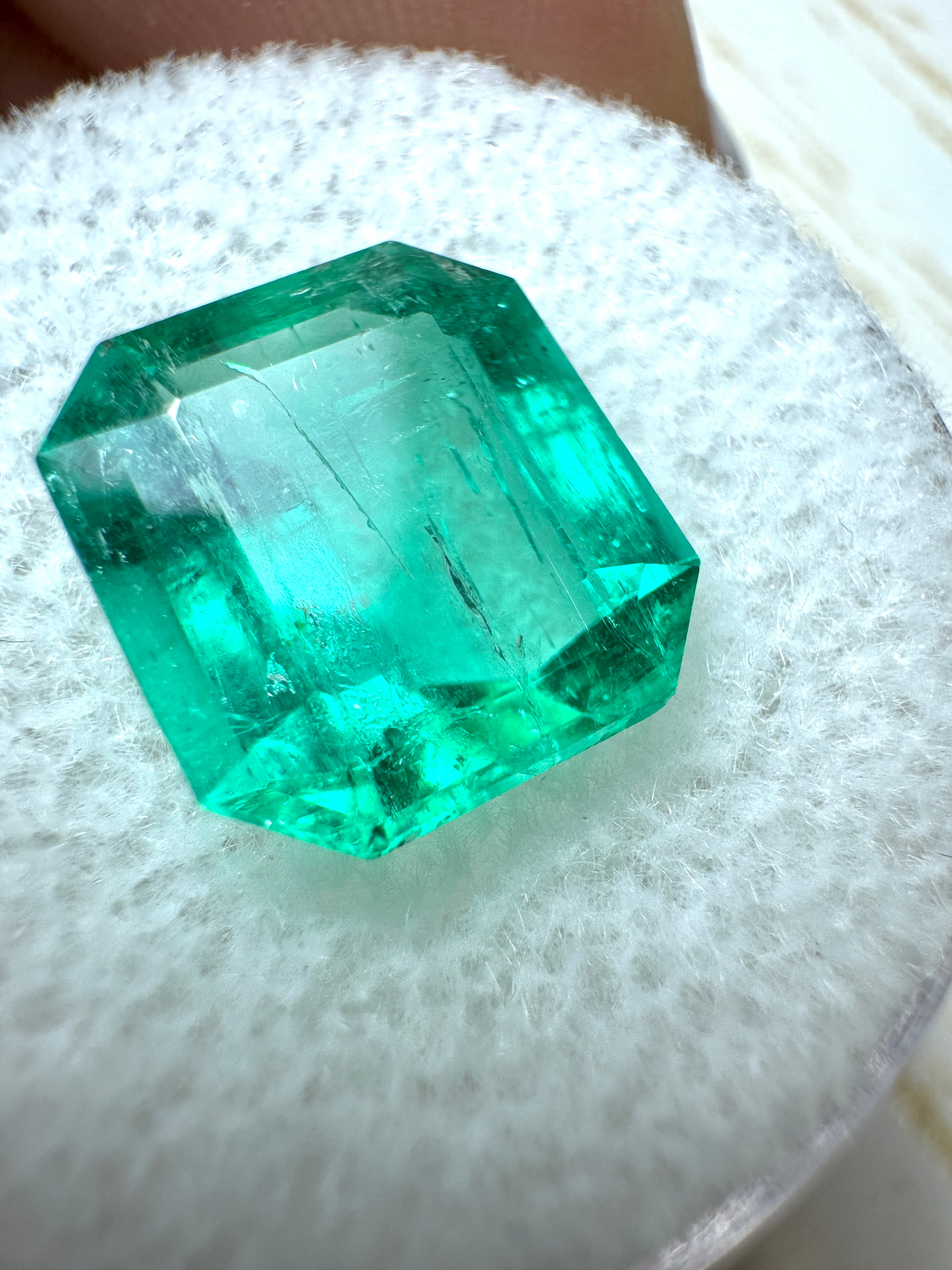 4.72 carat bluish natural Colombian emerald loose Asscher cut gemstone with 11x10mm dimensions, displayed on a plain background.