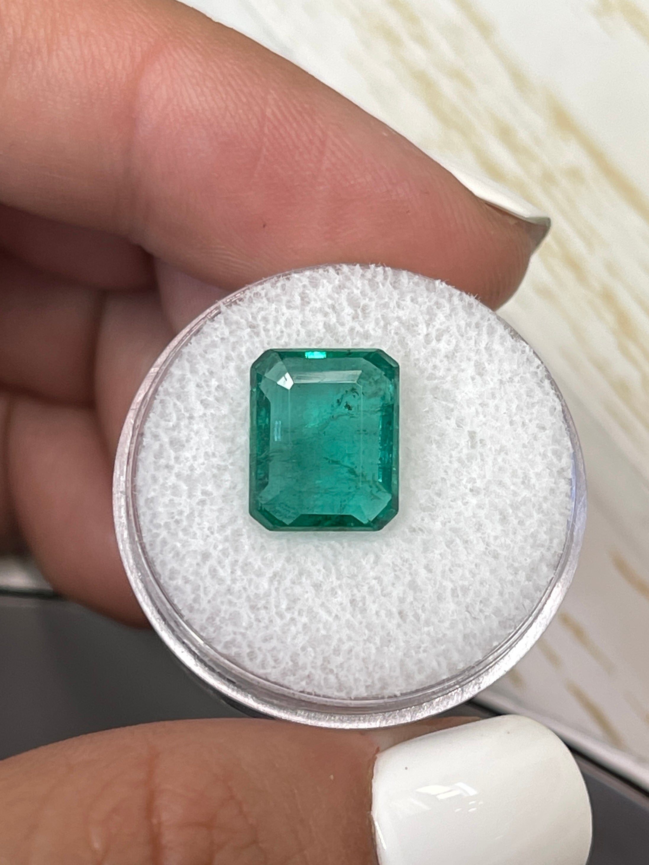 Bluish green 5.16 carat natural Zambian emerald cut loose gemstone by JR Colombian Emeralds, showing its vibrant color and clarity.