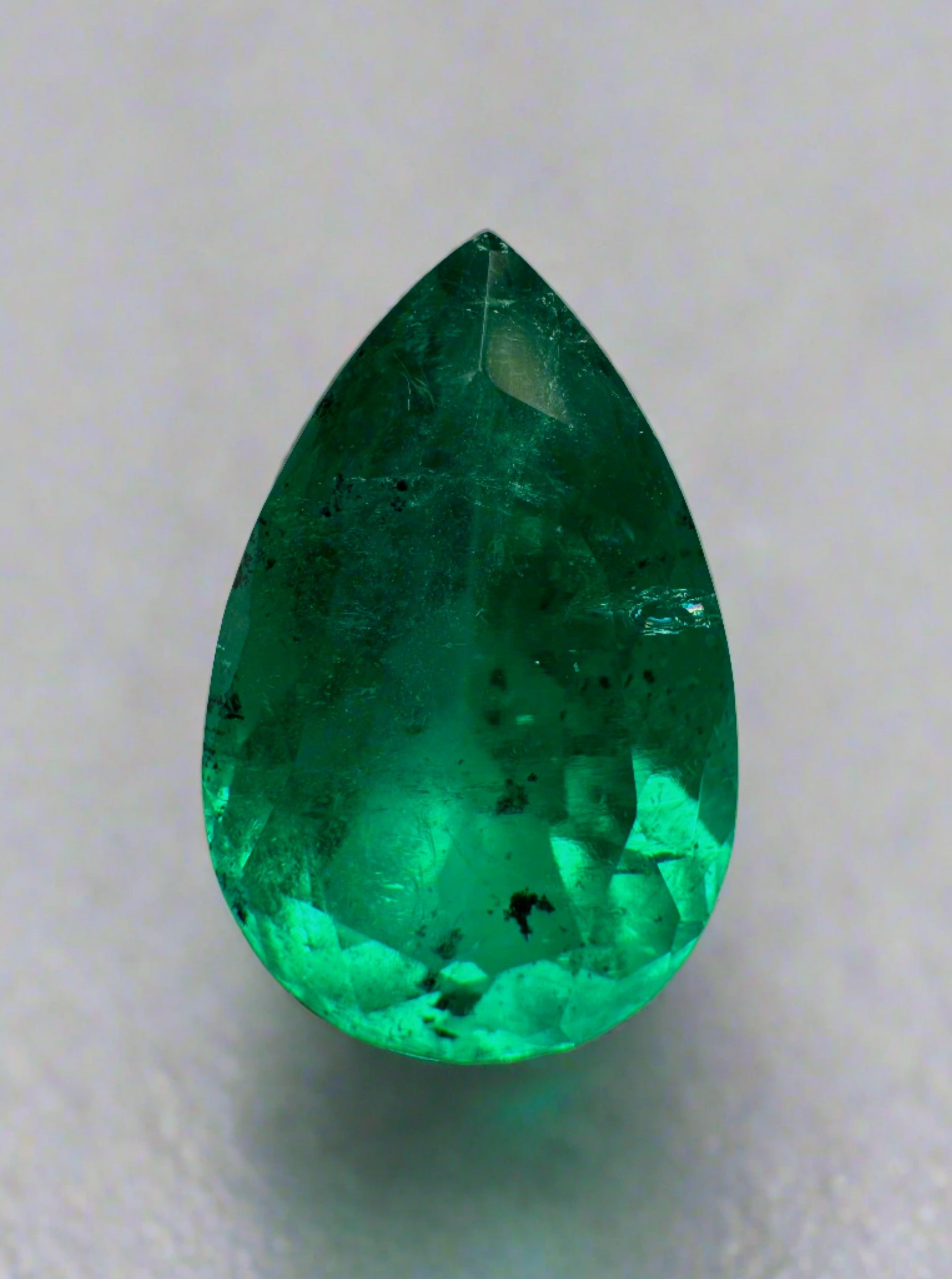 Natural 5.18 carat Colombian emerald loose gemstone with pear cut and unique freckled appearance, from JR Colombian Emeralds.