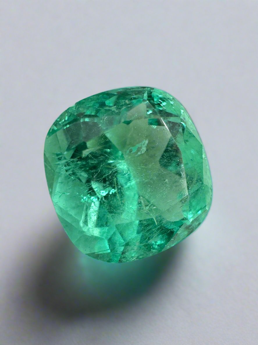 Bright bluish-green 5.20 carat natural Colombian emerald in cushion cut, showcasing its vibrant color and clarity.