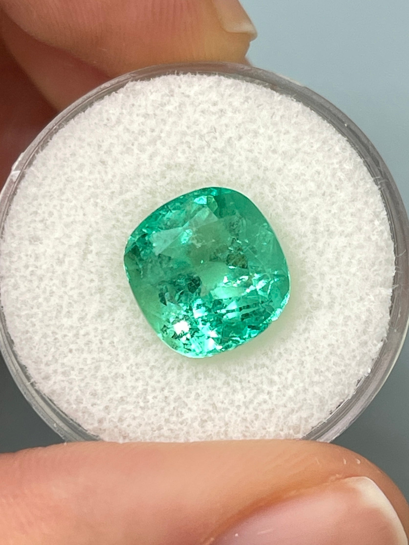 Bright bluish green 5.20 carat natural Colombian emerald in cushion cut, loose gemstone showcasing vibrant color and clarity.
