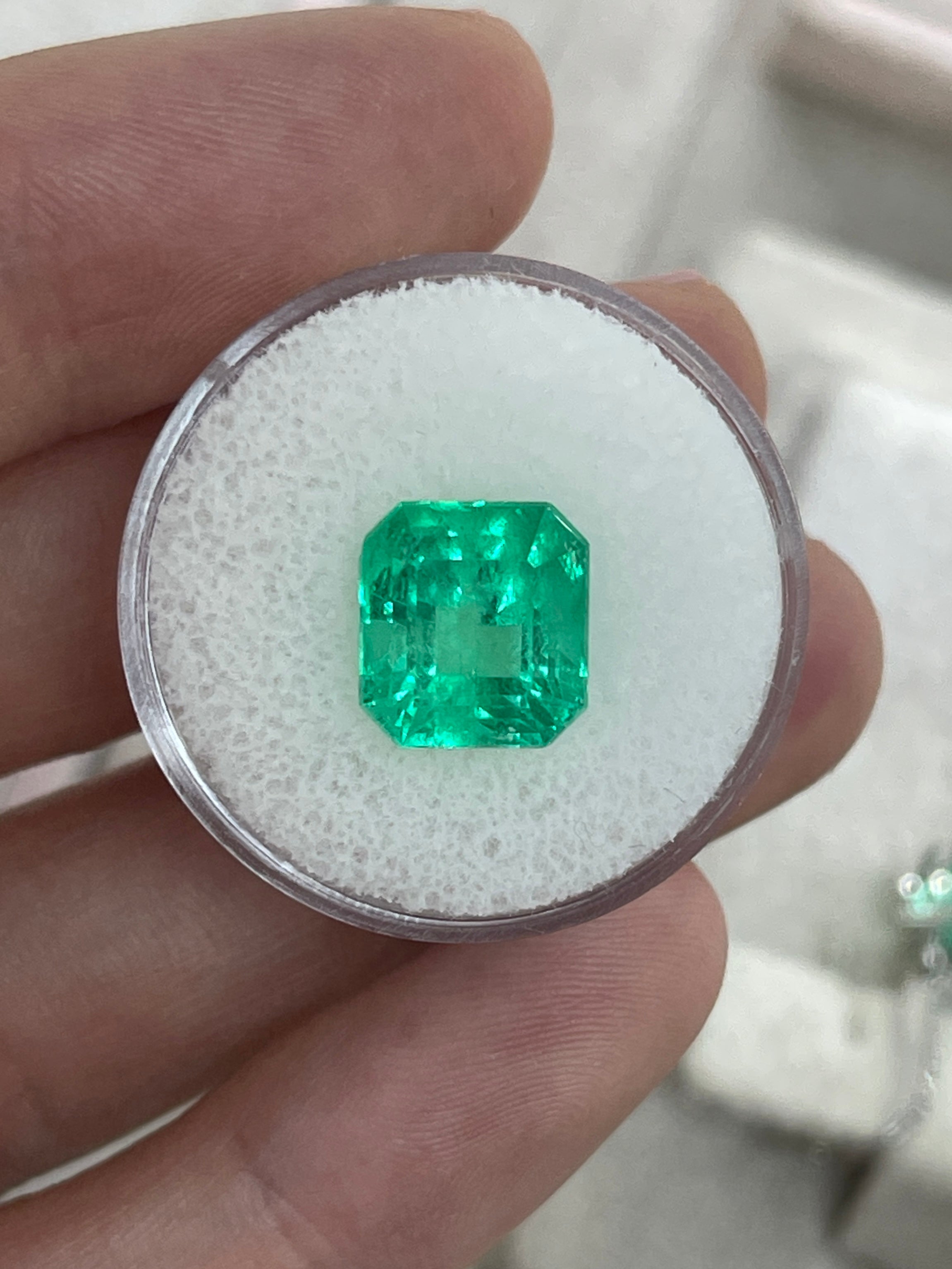 Vibrant 5.29 carat loose Colombian emerald in Asscher cut with 10.5x10mm dimensions, from JR Colombian Emeralds.