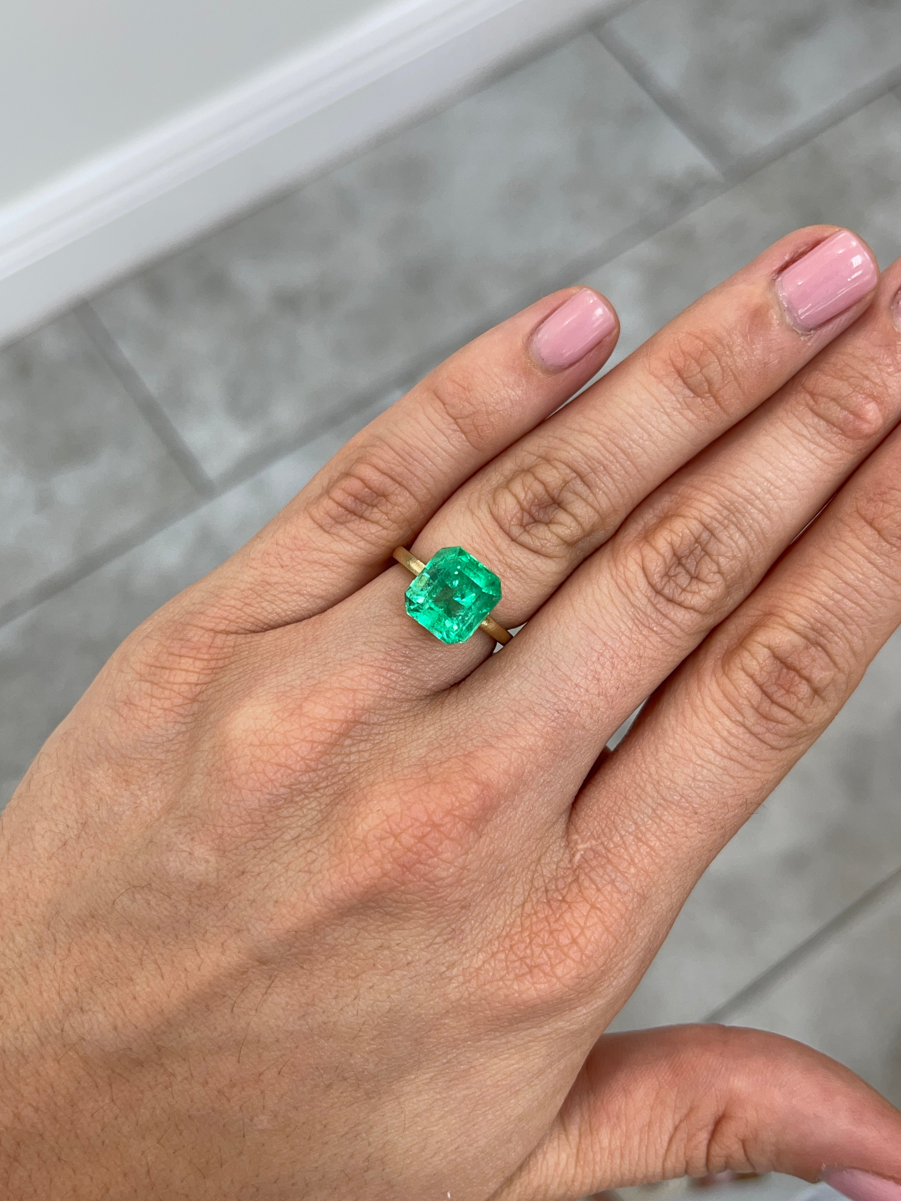 Vibrant 5.29 carat loose Colombian emerald in an Asscher cut, showcasing bright green color and clarity.