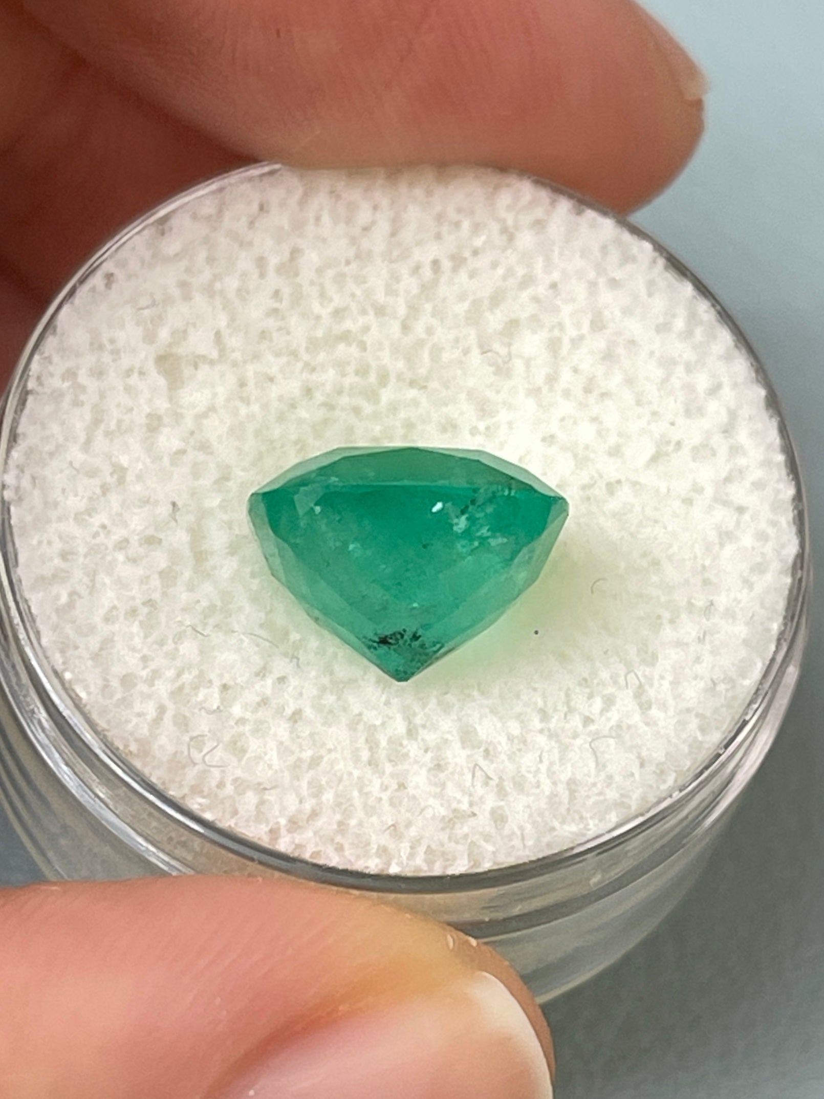 Natural 5.33 carat earthy Colombian emerald in cushion cut, loose gemstone from JR Colombian Emeralds, with vibrant green hues.