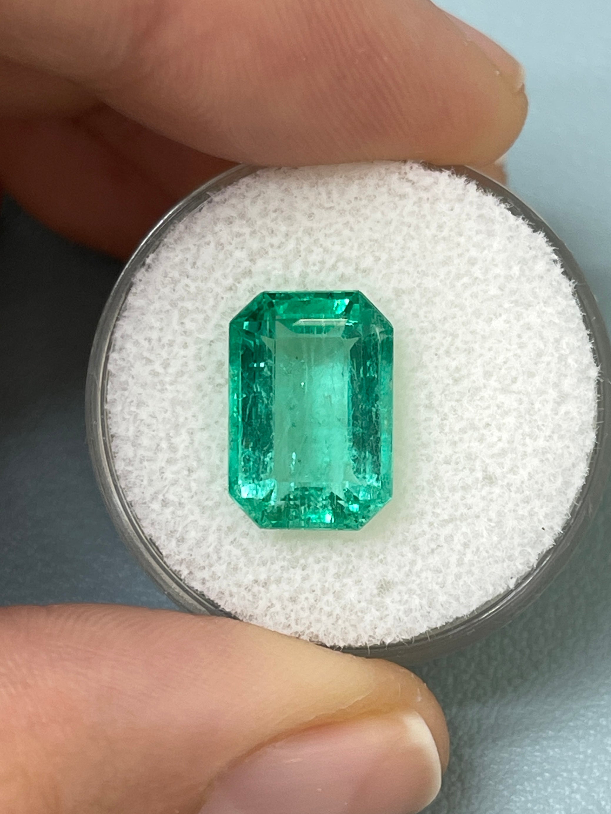 Bluish green 5.45 carat natural loose emerald cut gemstone from JR Colombian Emeralds, showcasing a clear, vibrant stone.