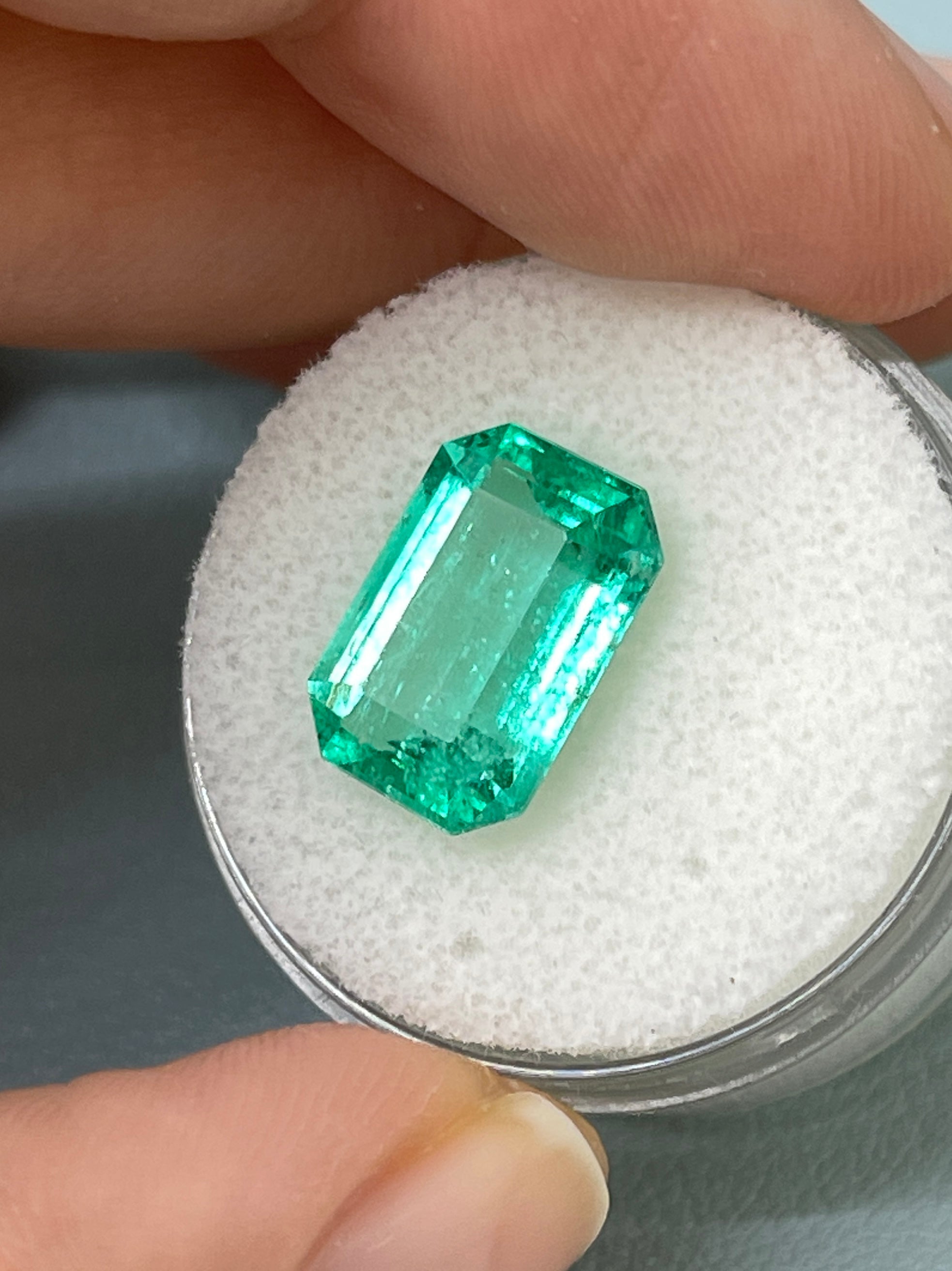 Natural 5.45 carat bluish green emerald cut loose gemstone from JR Colombian Emeralds, showcasing its vibrant color and clarity.
