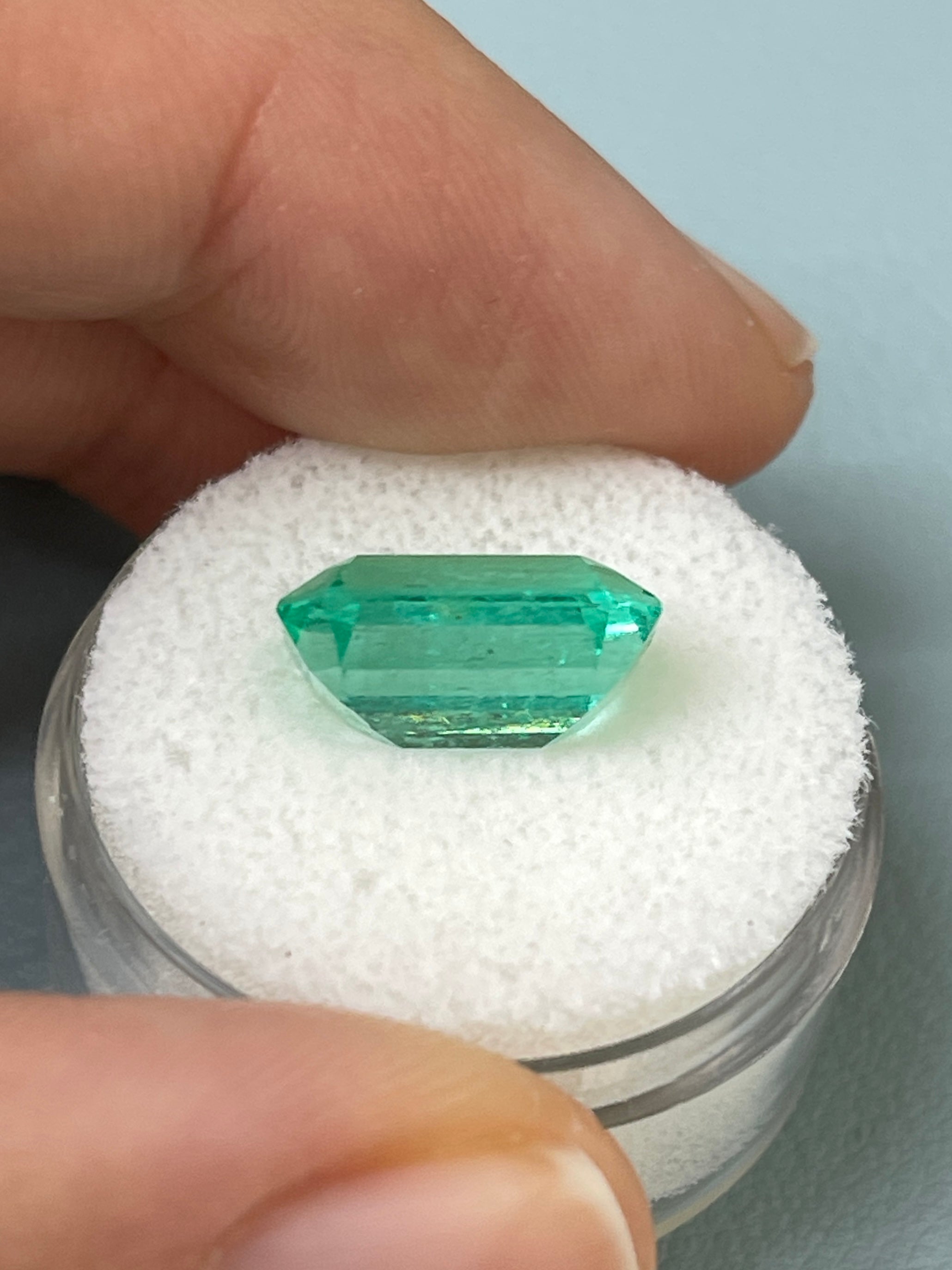 Bluish green 5.45 carat natural loose emerald cut emerald from JR Colombian Emeralds, showing clarity and vibrant color.