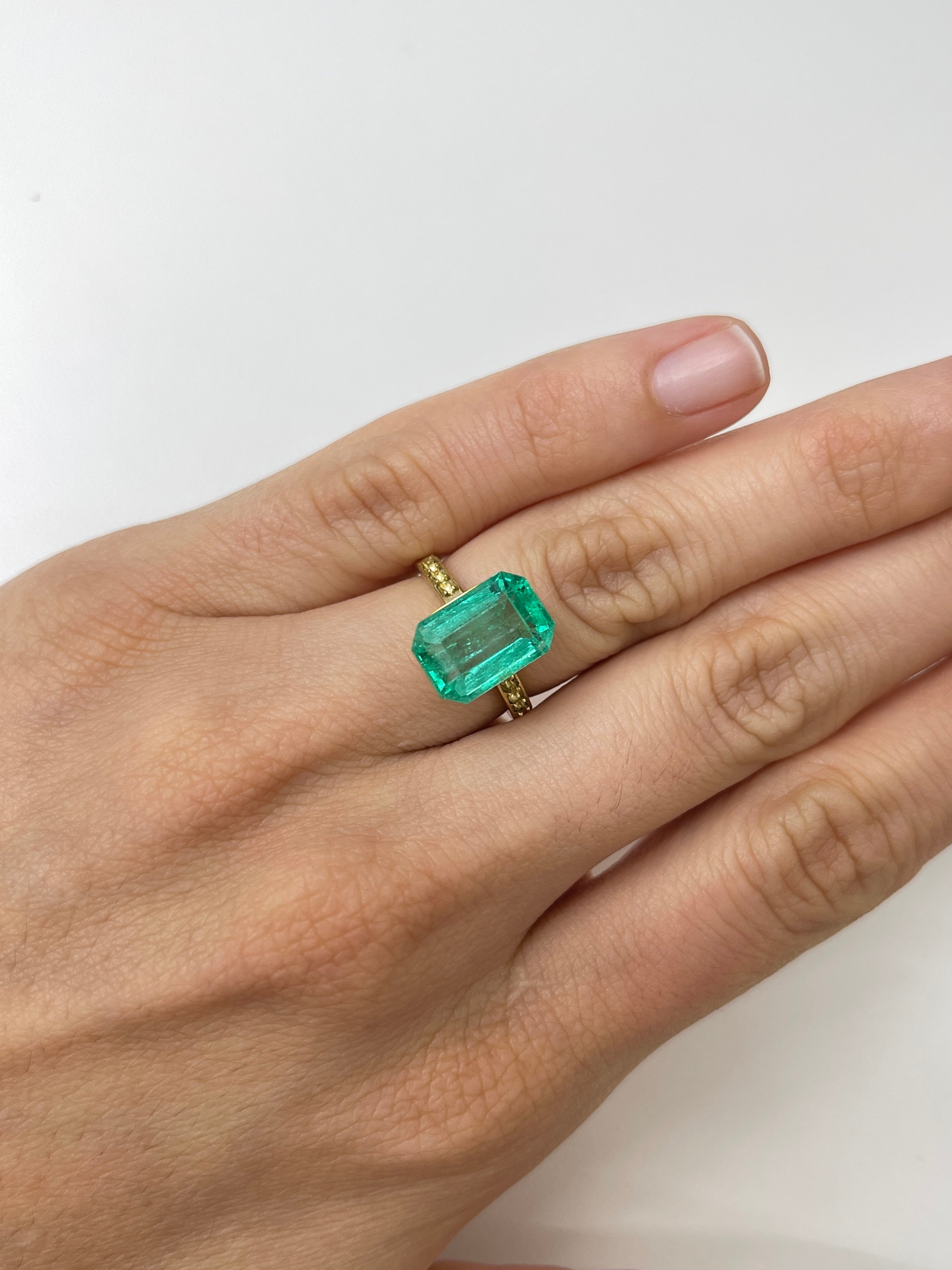 Bluish green 5.45 carat natural loose emerald cut gemstone from JR Colombian Emeralds, showcasing its vibrant color and clarity.