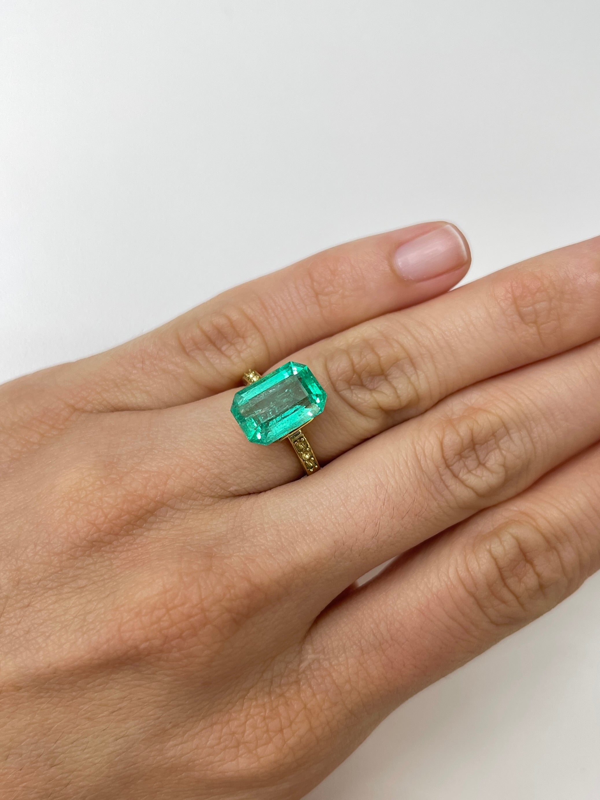 Natural bluish green 5.45 carat loose emerald cut gemstone from JR Colombian Emeralds, showcasing clarity and vibrant color.