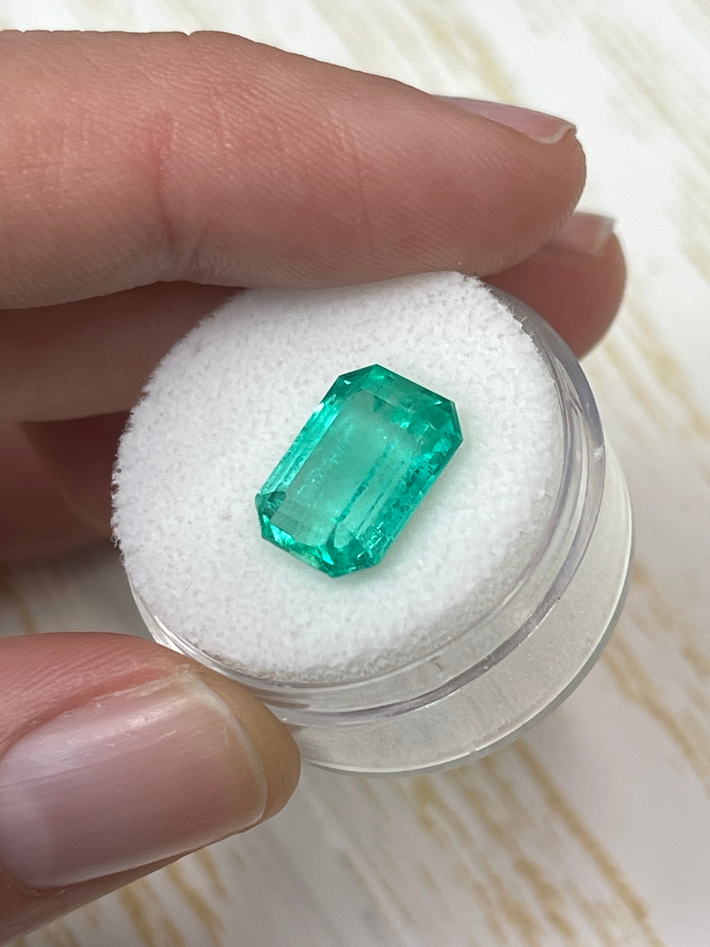 5.54 carat spring green Colombian emerald in an elongated emerald cut, natural loose gemstone displayed by JR Colombian Emeralds