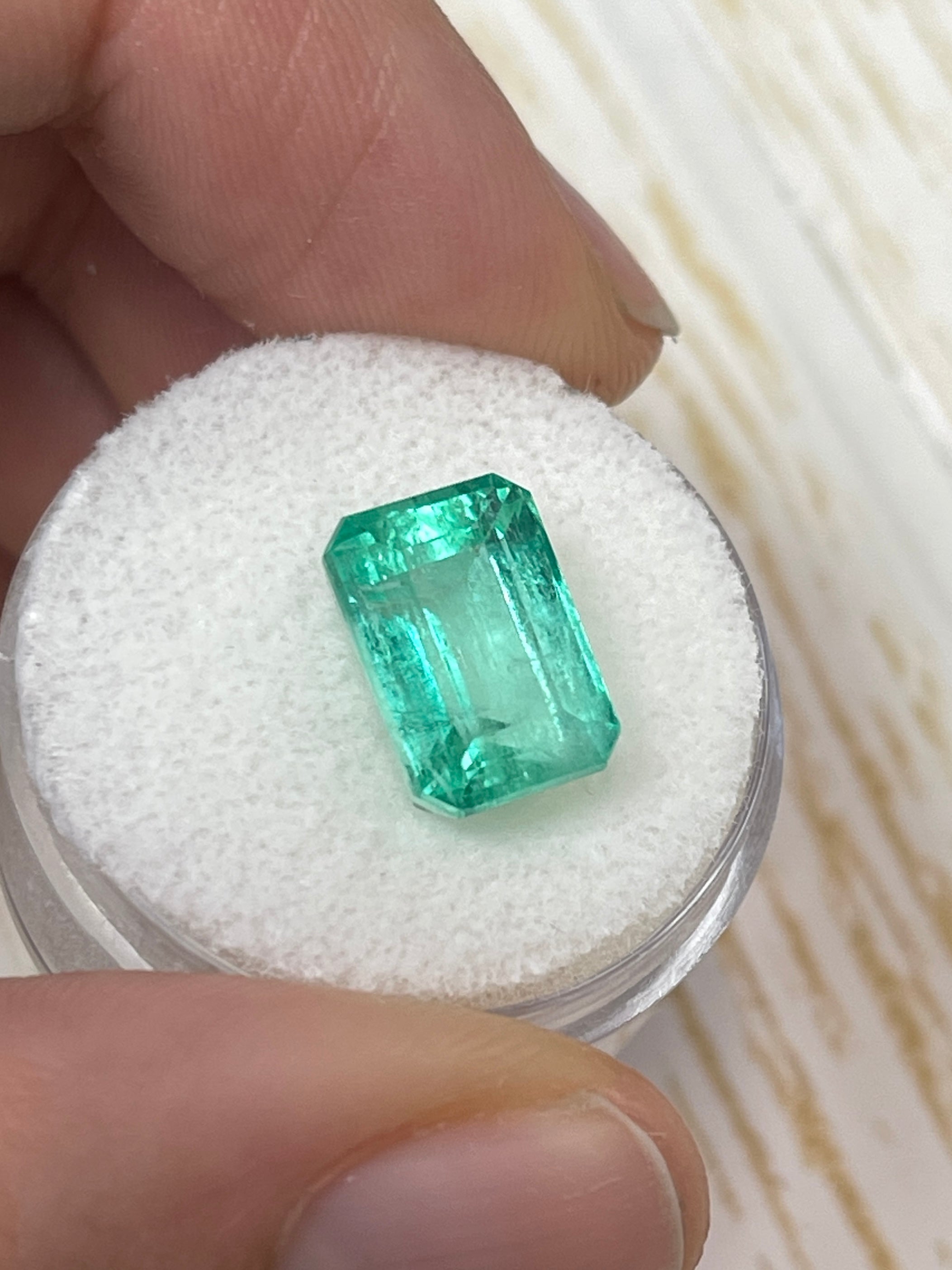 5.55 carat pastel green Colombian emerald loose gemstone in an emerald cut, showcasing natural color and clarity.