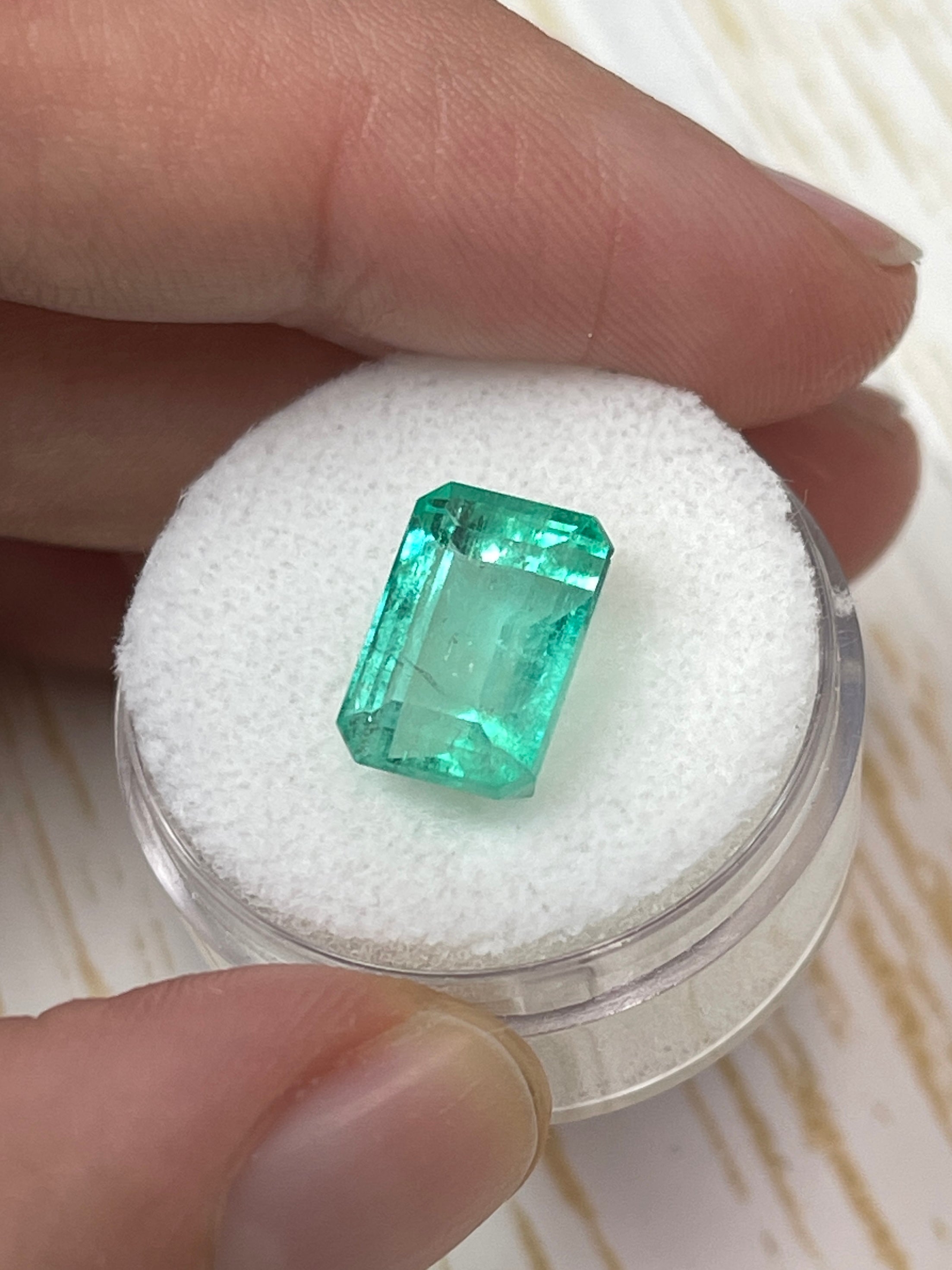 Natural 5.55 carat 12x8 pastel green Colombian emerald loose gemstone in emerald cut, showcasing vibrant color and clarity.