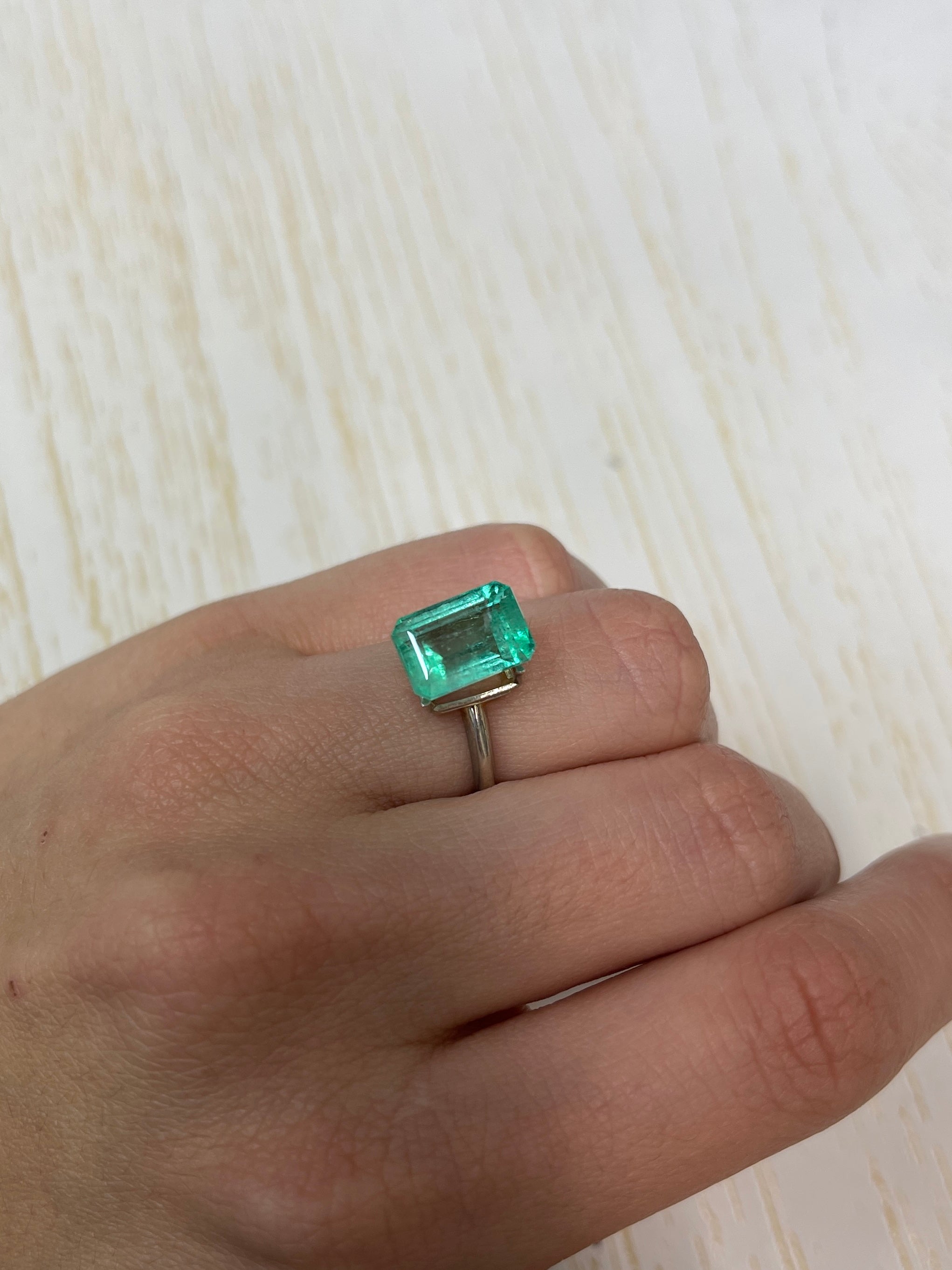 5.55 carat pastel green natural Colombian emerald loose gemstone in emerald cut, showcasing vibrant color and clarity.
