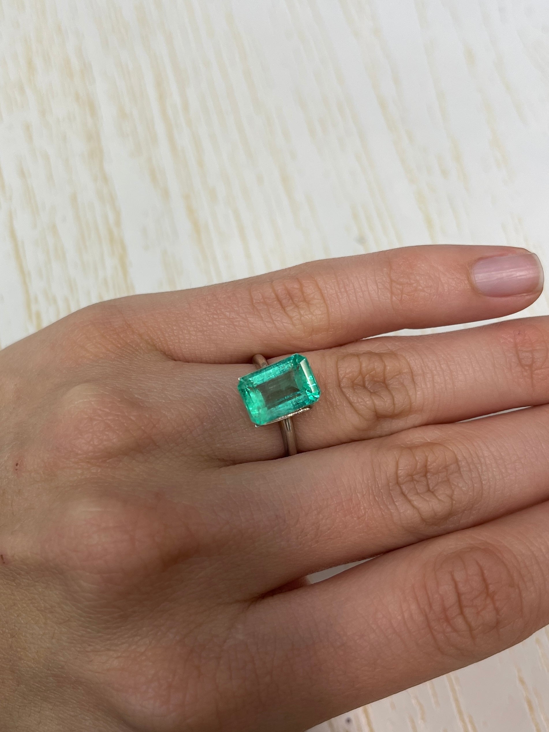 Loose 5.55 carat pastel green Colombian emerald in an emerald cut, showcasing its natural beauty and vibrant color.