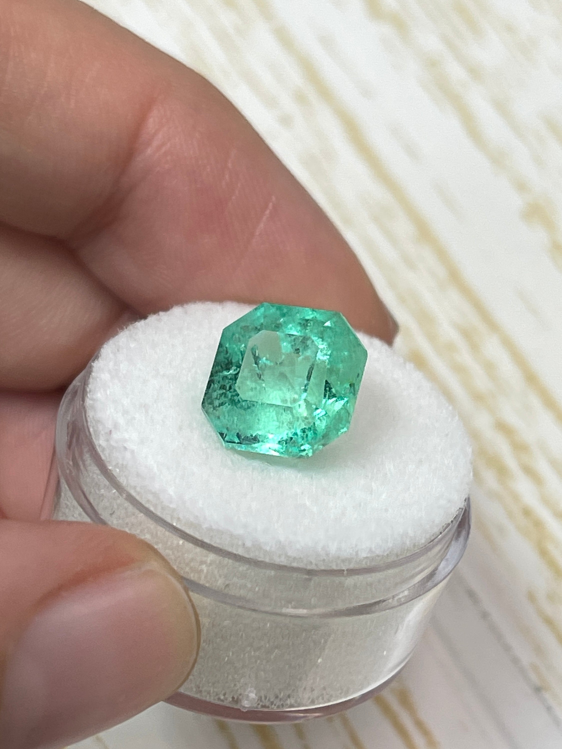 Natural 5.56 carat spring green Colombian emerald, loose Asscher cut gemstone with vibrant color and clarity.