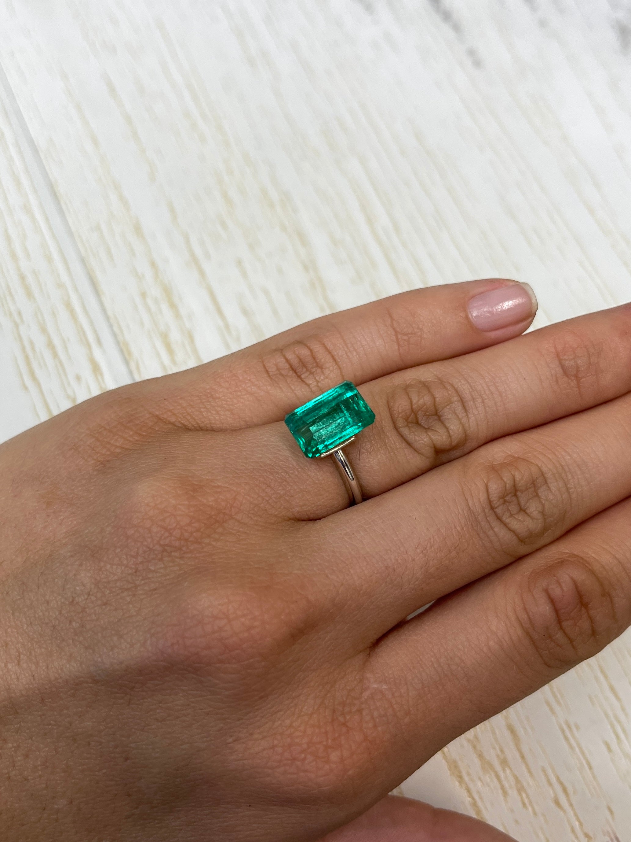 5.63 carat VS bluish-green natural Colombian emerald in an emerald cut, displayed as a loose gemstone.
